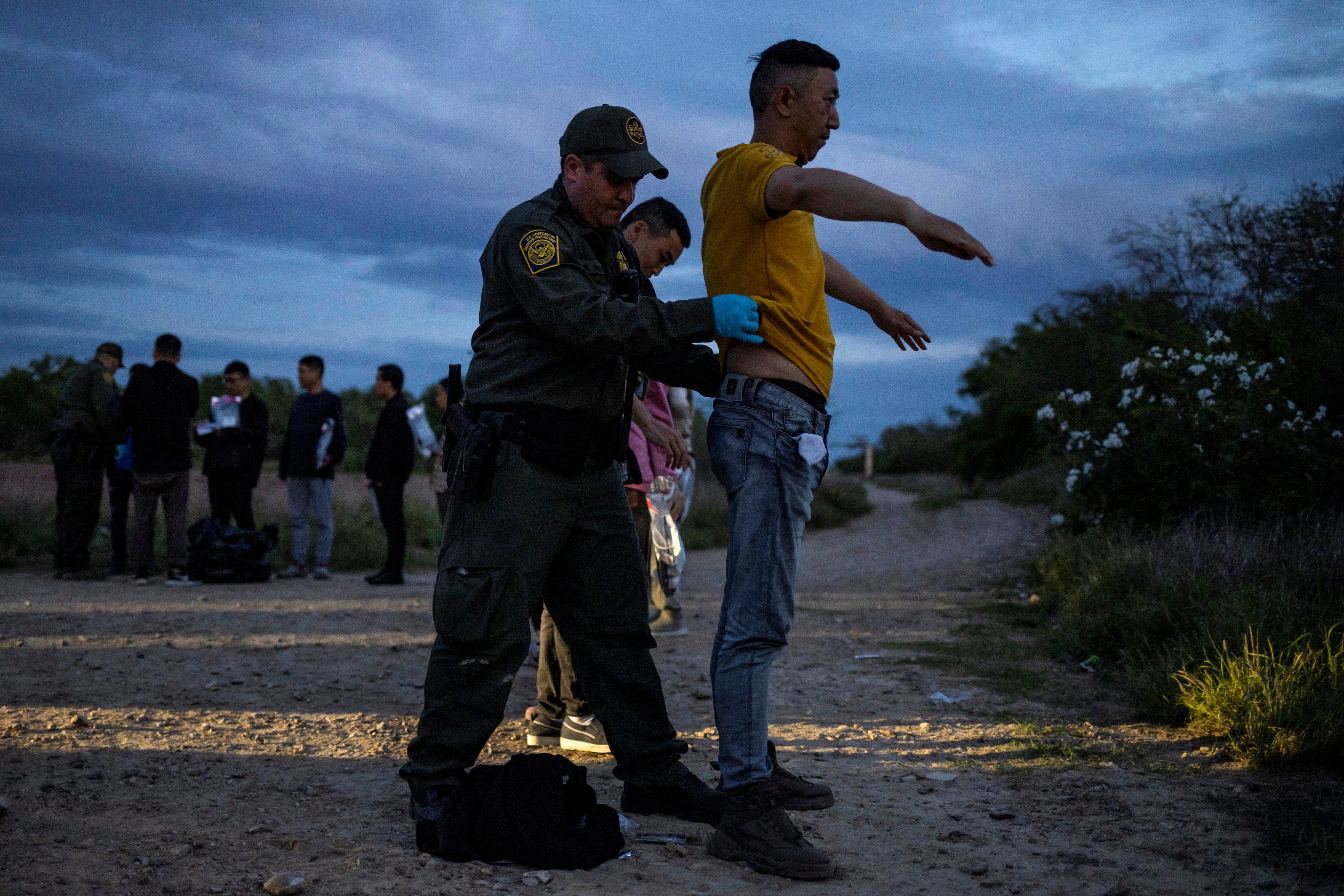 A US border patrol agent searches a migrant from China as he surrenders after crossing the into the United States from Mexico in April 2023. Photo: Reuters