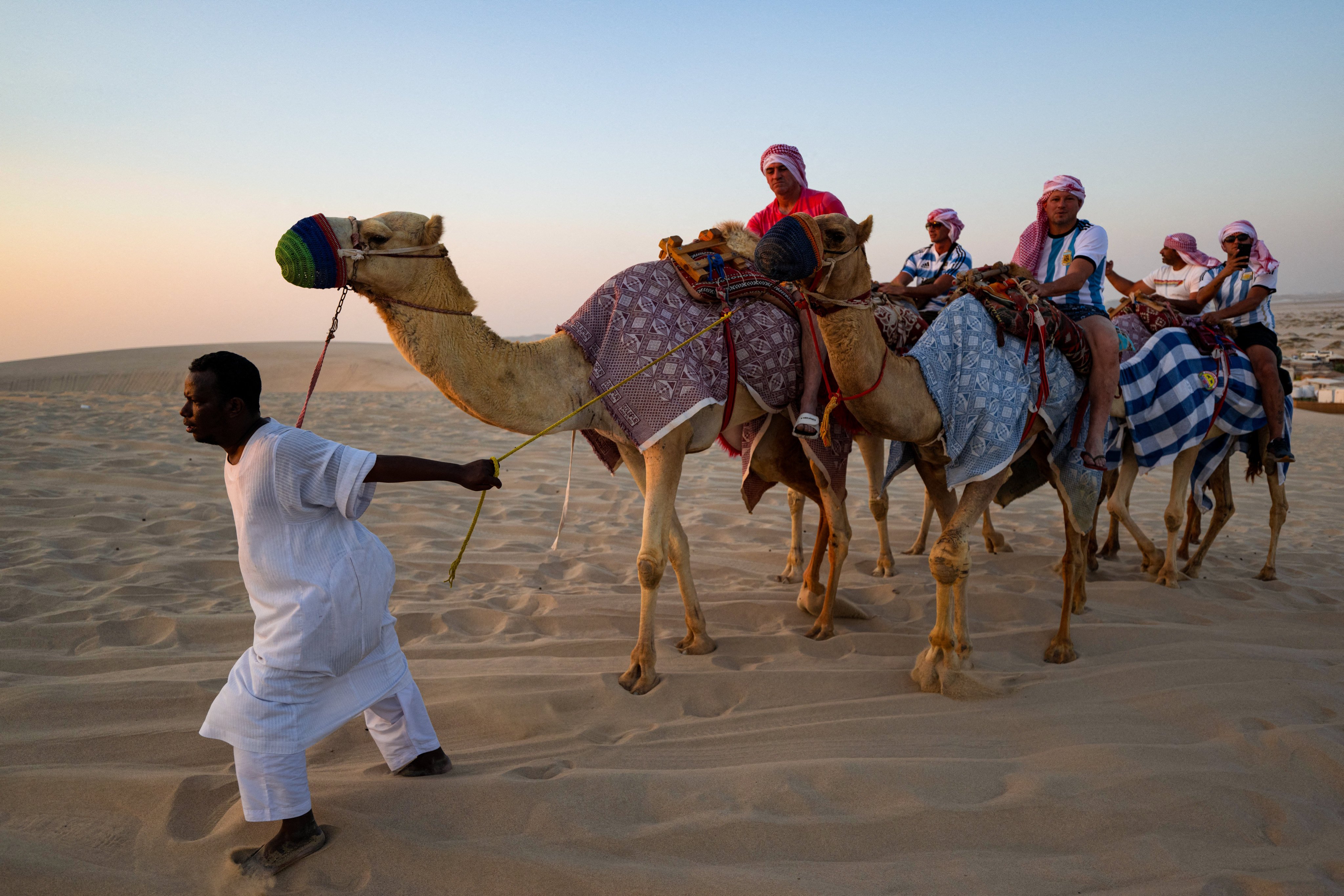 Tourists ride camels in a desert near Doha during the 2022 World Cup tournament. Photo: AFP