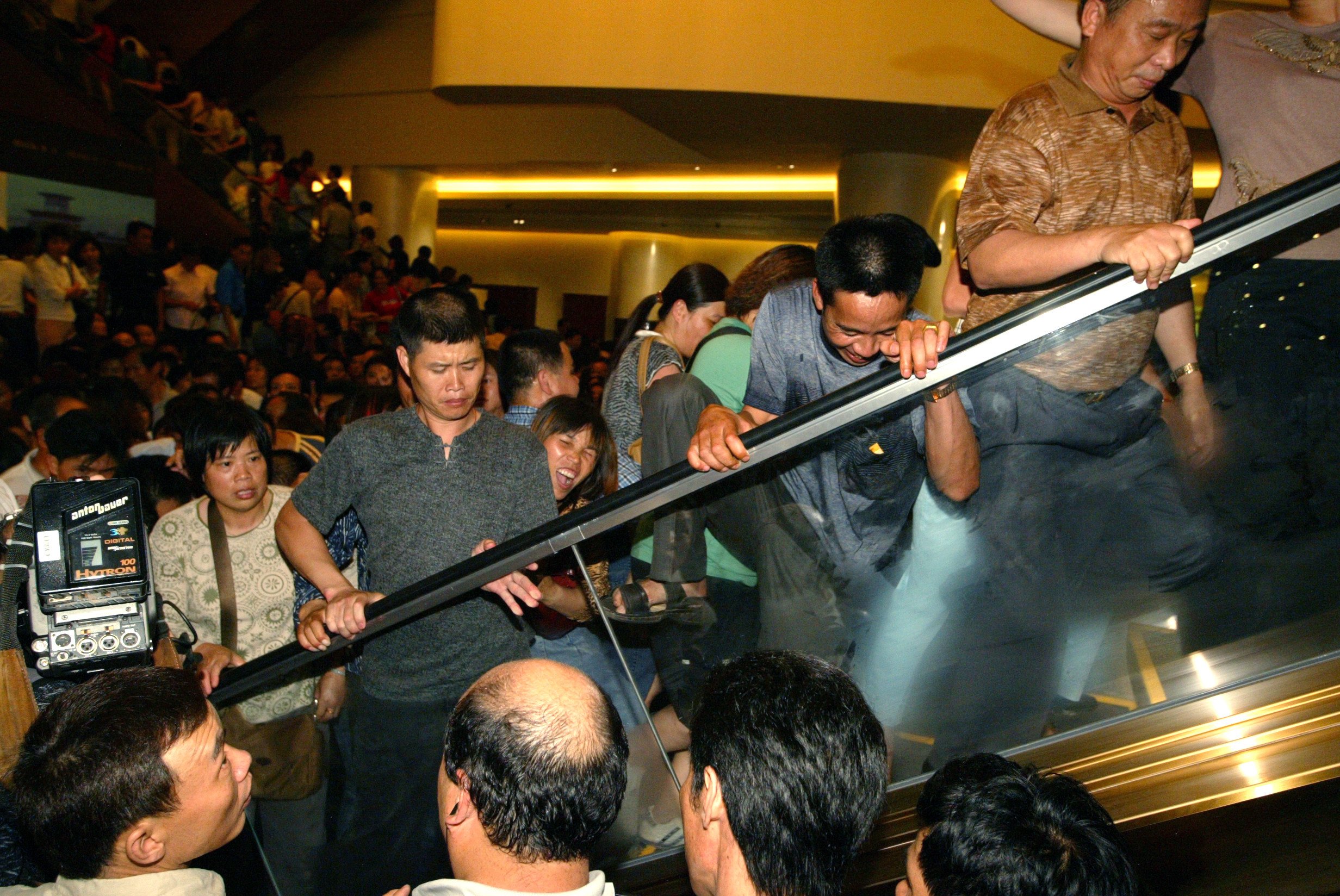 Hundreds of security officers have trouble controlling the crowds that gather outside, many of them lured by false newspaper reports that free gambling chips would be handed to first-day guests on May 18, 2004. Photo: K.Y. Cheng