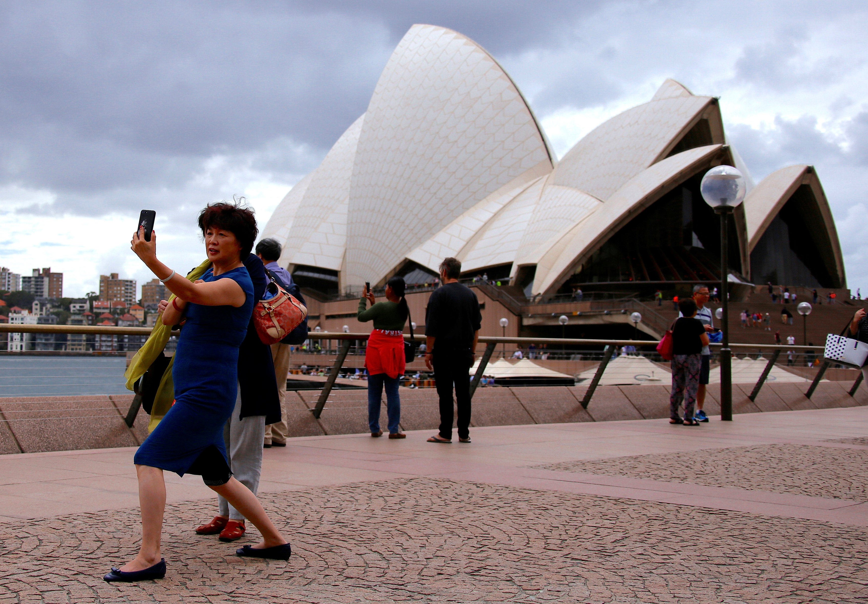 A Chinese tourist takes a selfie in front of the Sydney Opera House in Australia. Photo: Reuters
