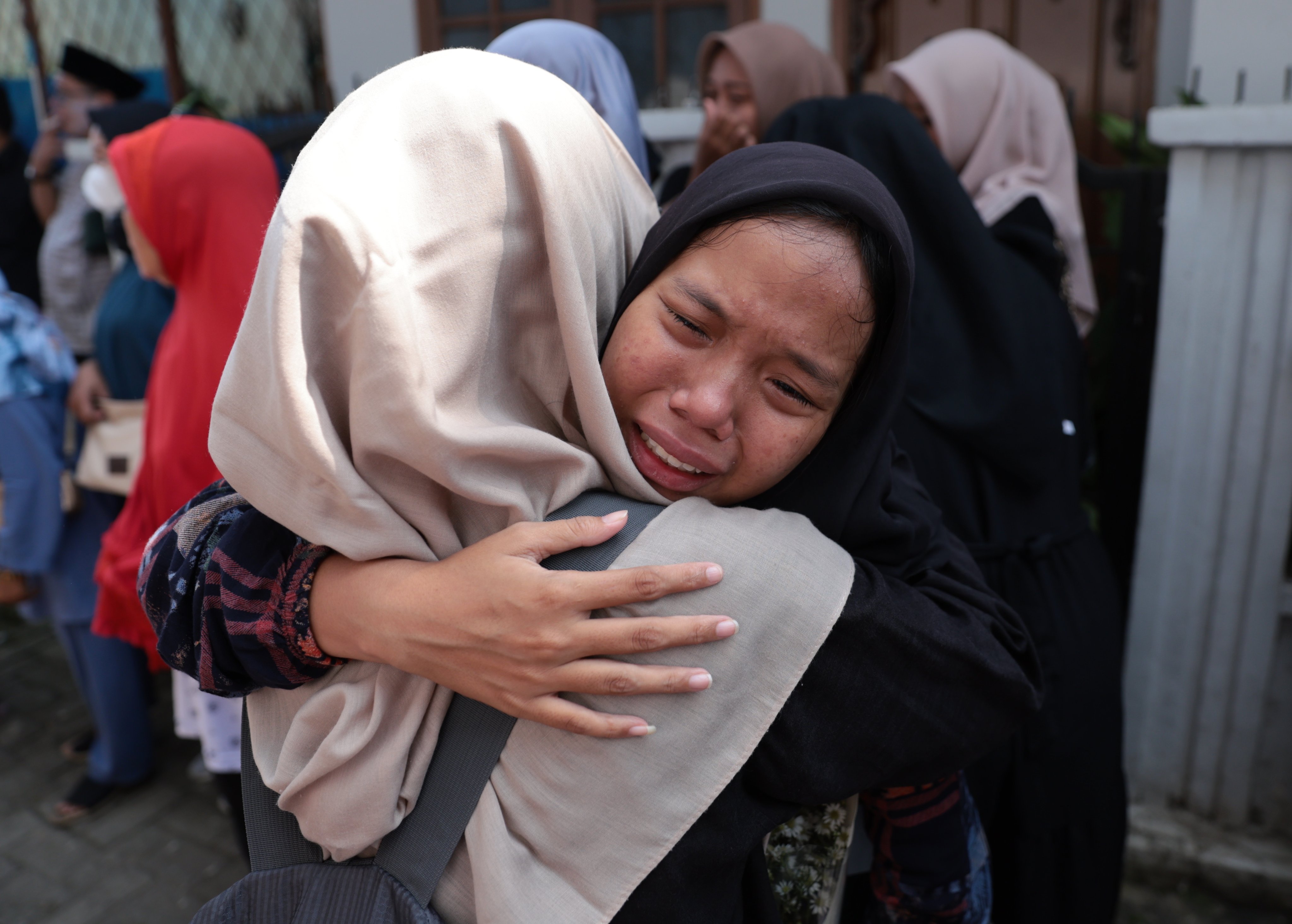Relatives of bus crash victims cry before a funeral in Depok, Indonesia, on Sunday. Photo: EPA-EFE