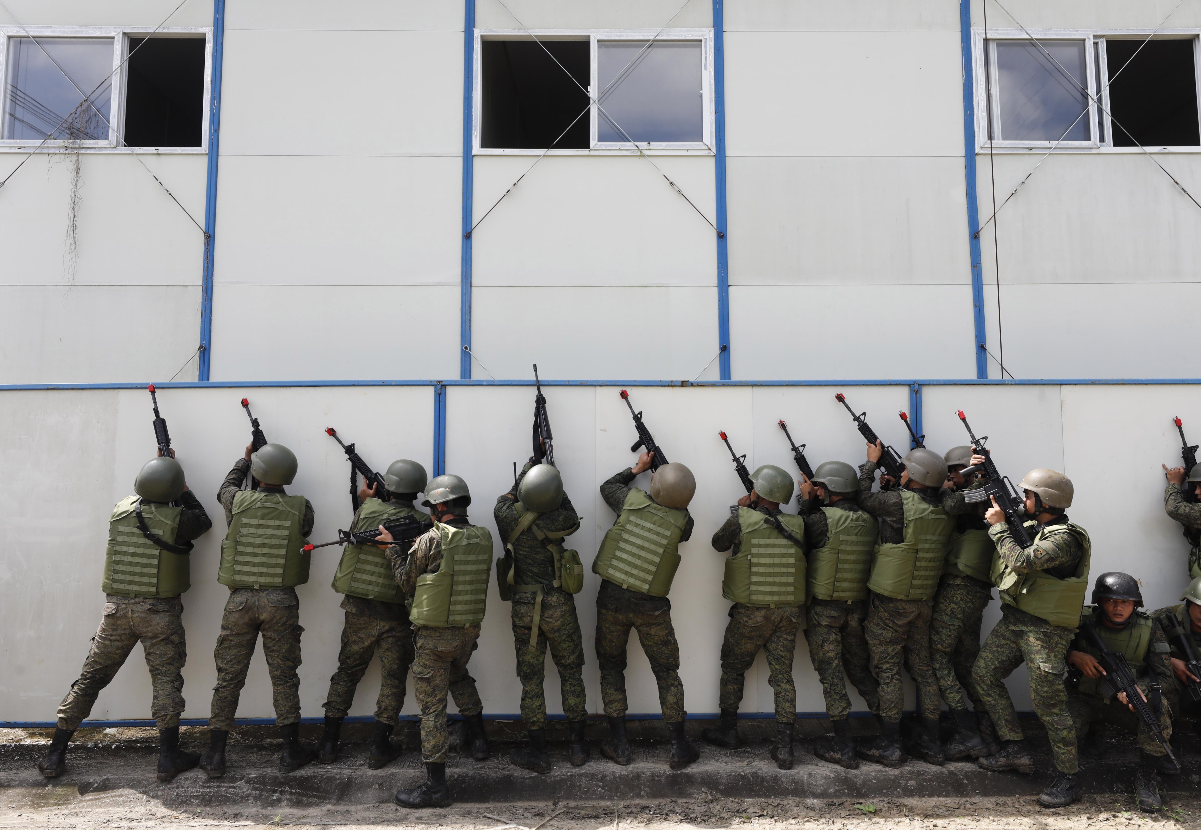 Soldiers of the Armed Forces of the Philippines take cover beside a wall during an assault exercise at Fort Magsaysay military camp north of Manila. Photo: EPA-EFE