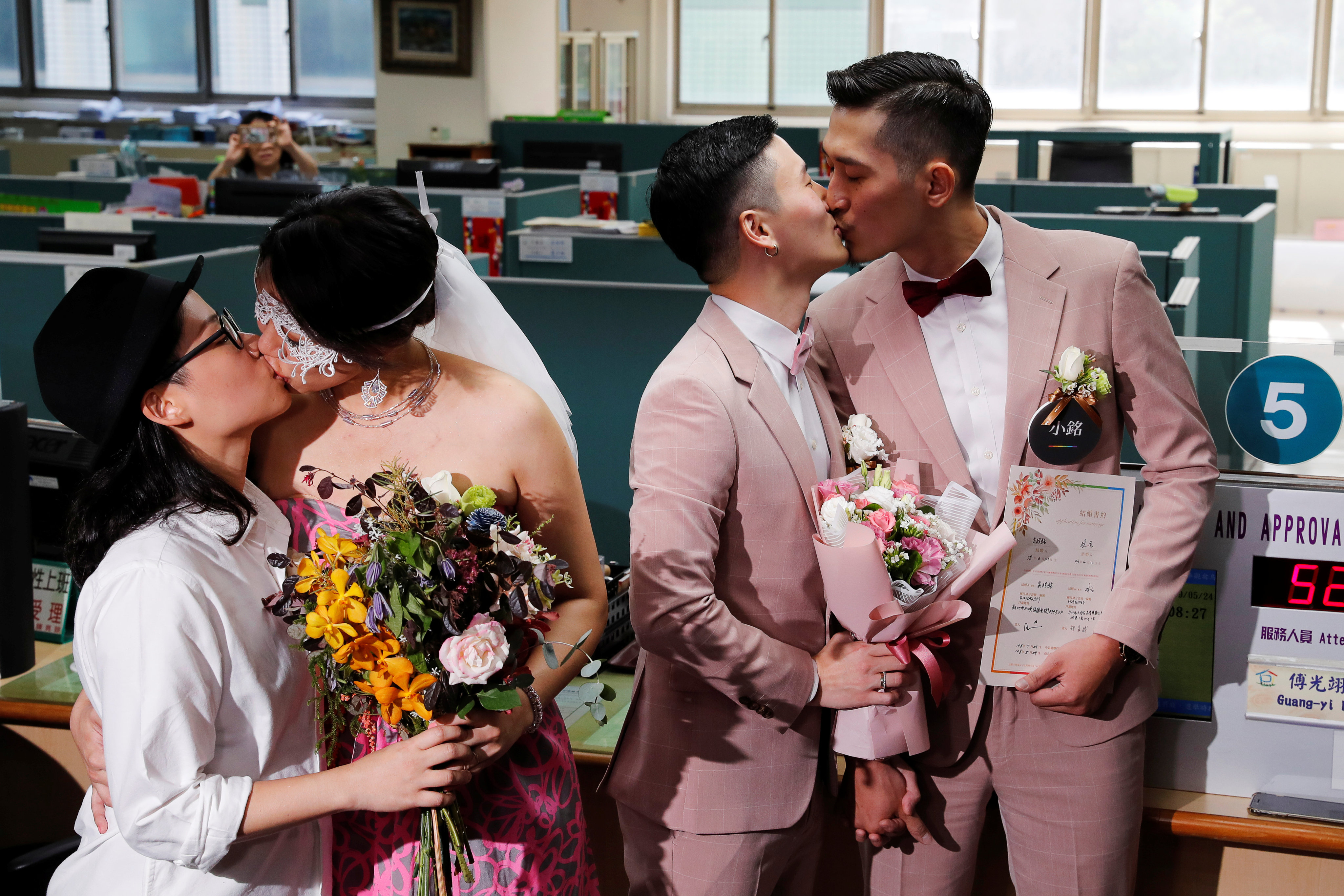 Couples Shane Lin (right) and Marc Yuan, and Cynical Chick (left) and Li Ying-Chien, kiss after registering for marriage at the Household Registration Office in Taipei, Taiwan on May 24, 2019. Photo: Reuters