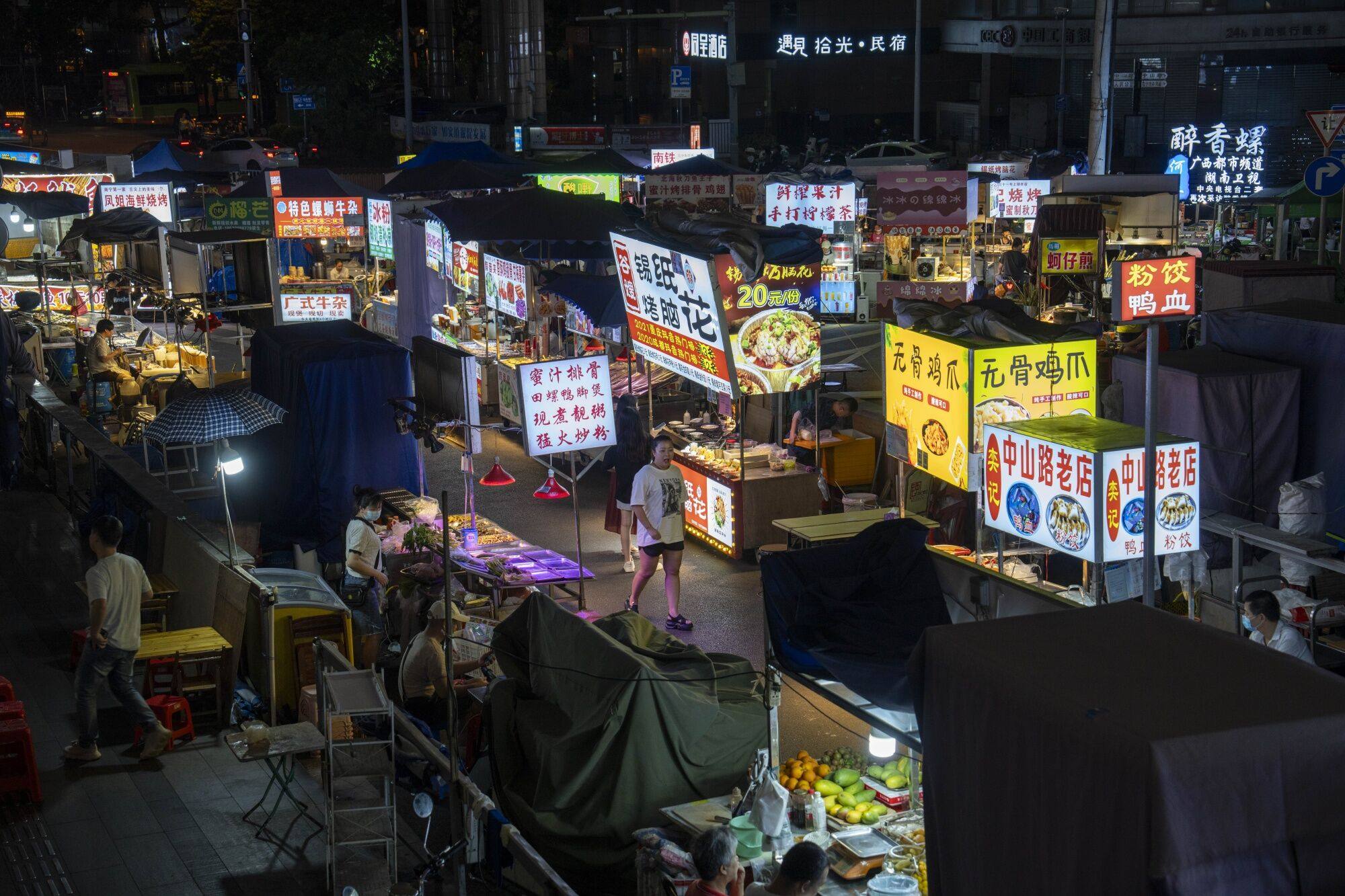 A shopper walks past food stalls at a night market in Nanning, China, on May 13. The Chinese economy is stabilising, which from a market standpoint is an important signal that the worst of the downturn is over. Photo: Bloomberg 