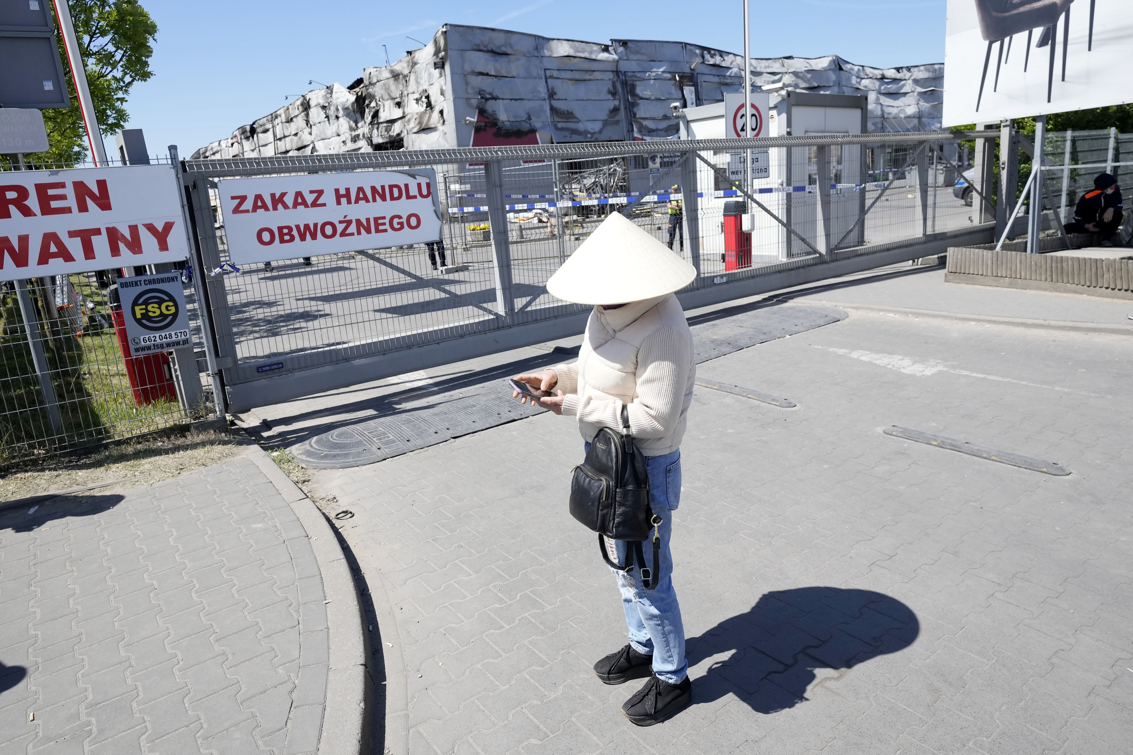A member of Poland’s Vietnamese community outside the shopping centre that was destroyed in a weekend fire. Photo: AP