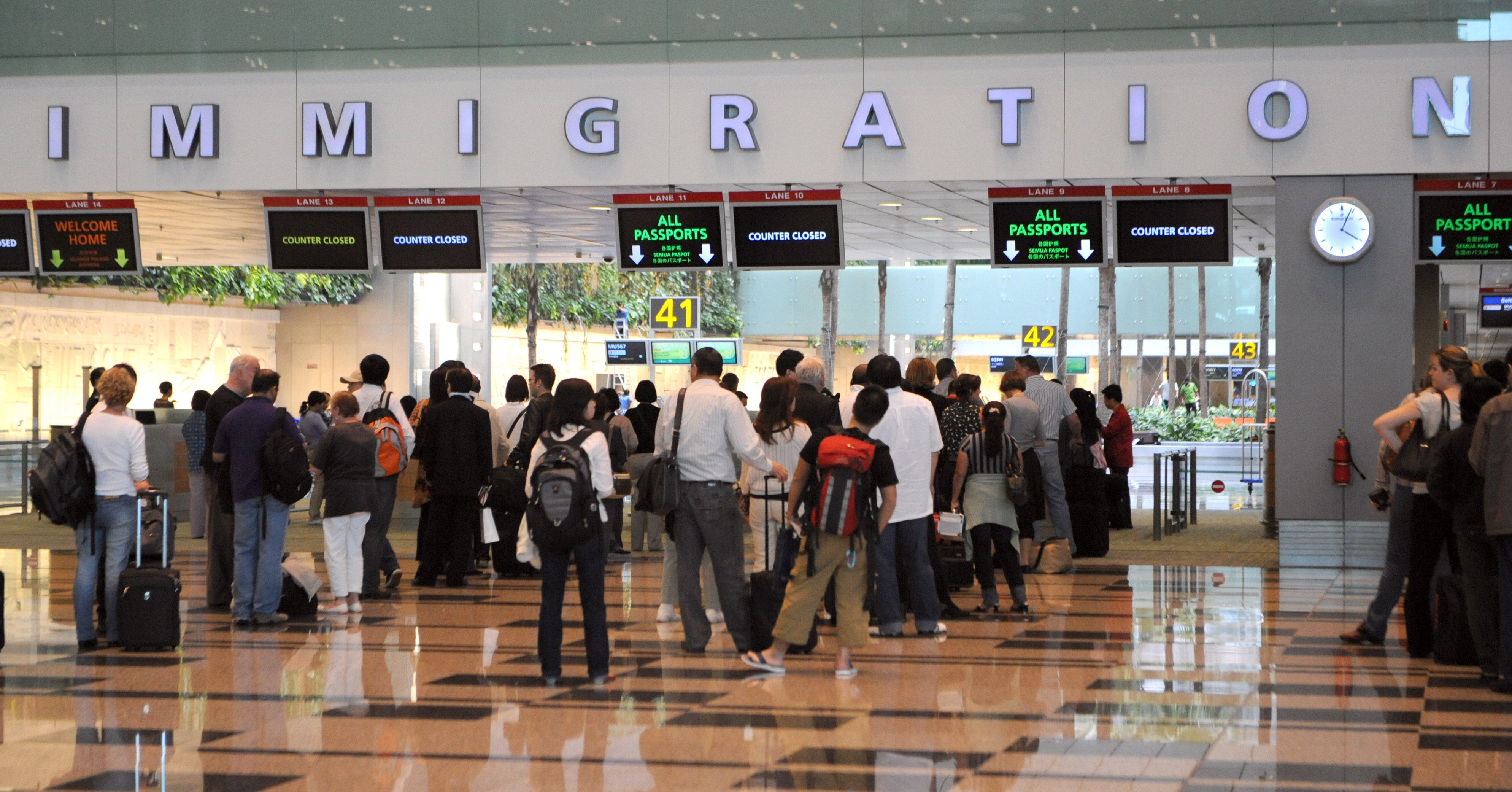 Visitors queing at the immigration counter after passing through health screening at the Changi International Airport in Singapore. Photo: AFP