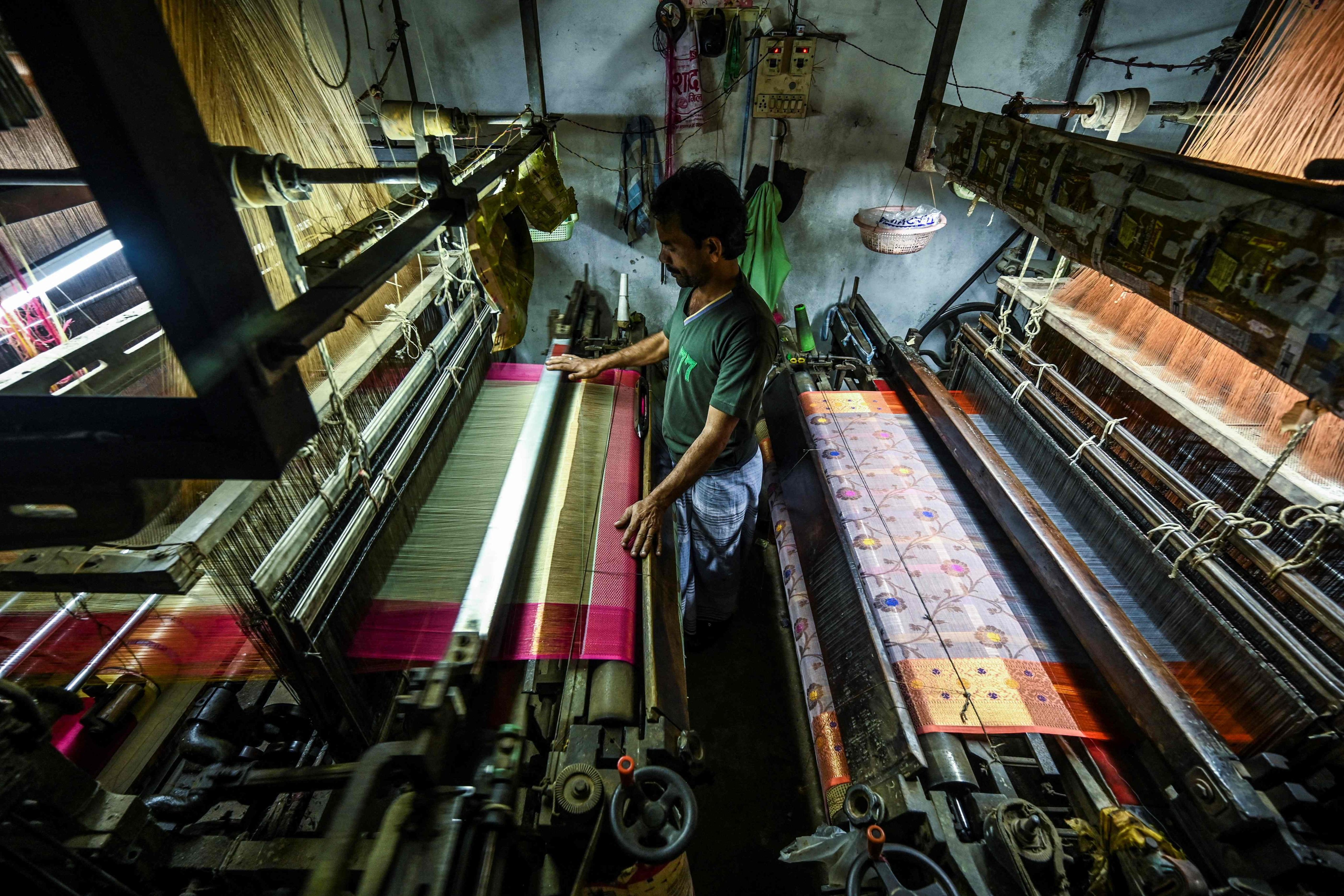 A worker uses a power looms to weave a Banarasi silk sari at a workshop in Varanasi. Photo: AFP