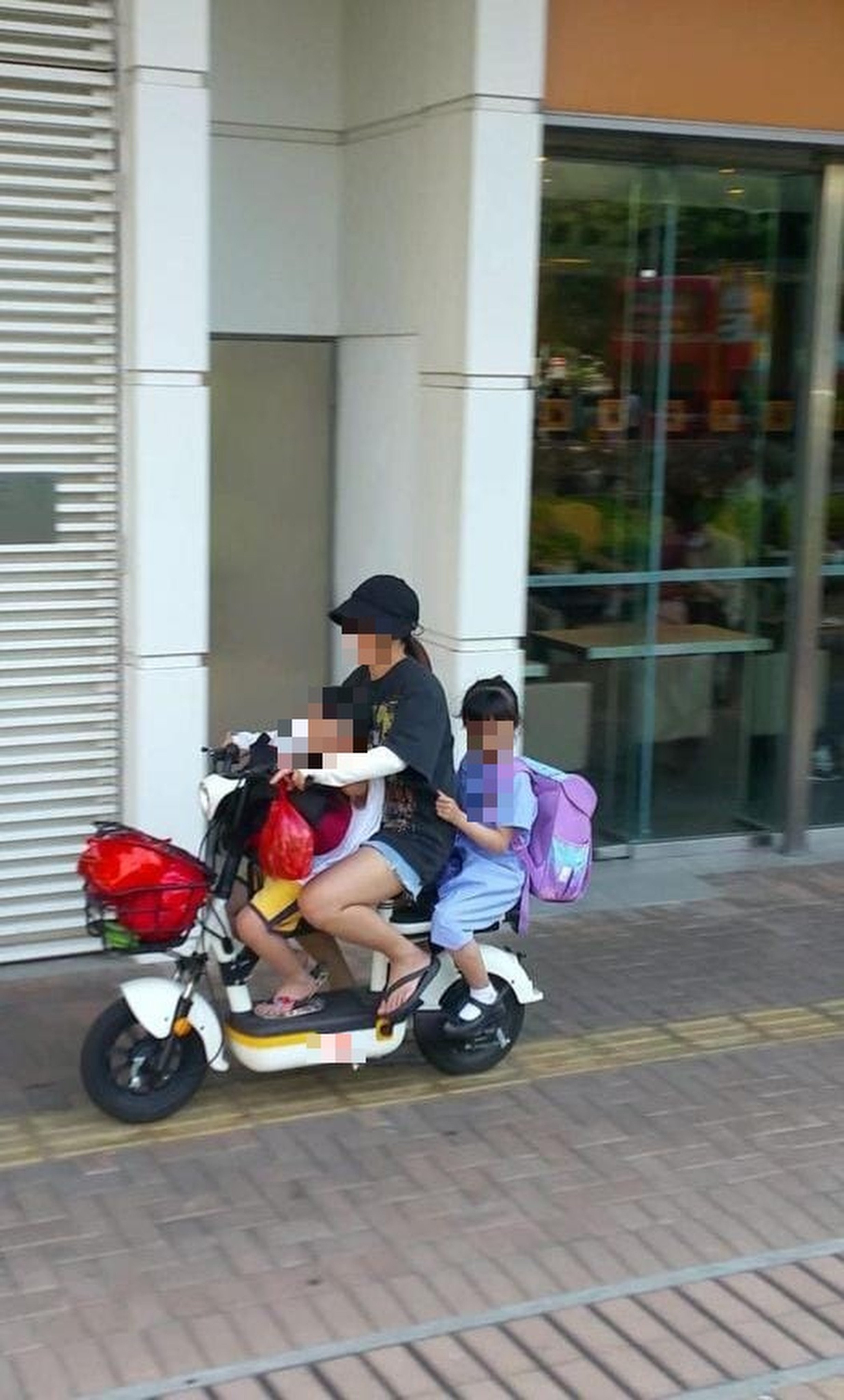 A woman was arrested for riding an e-bike with two children on the pavement. Photo: Hong Kong Police Force