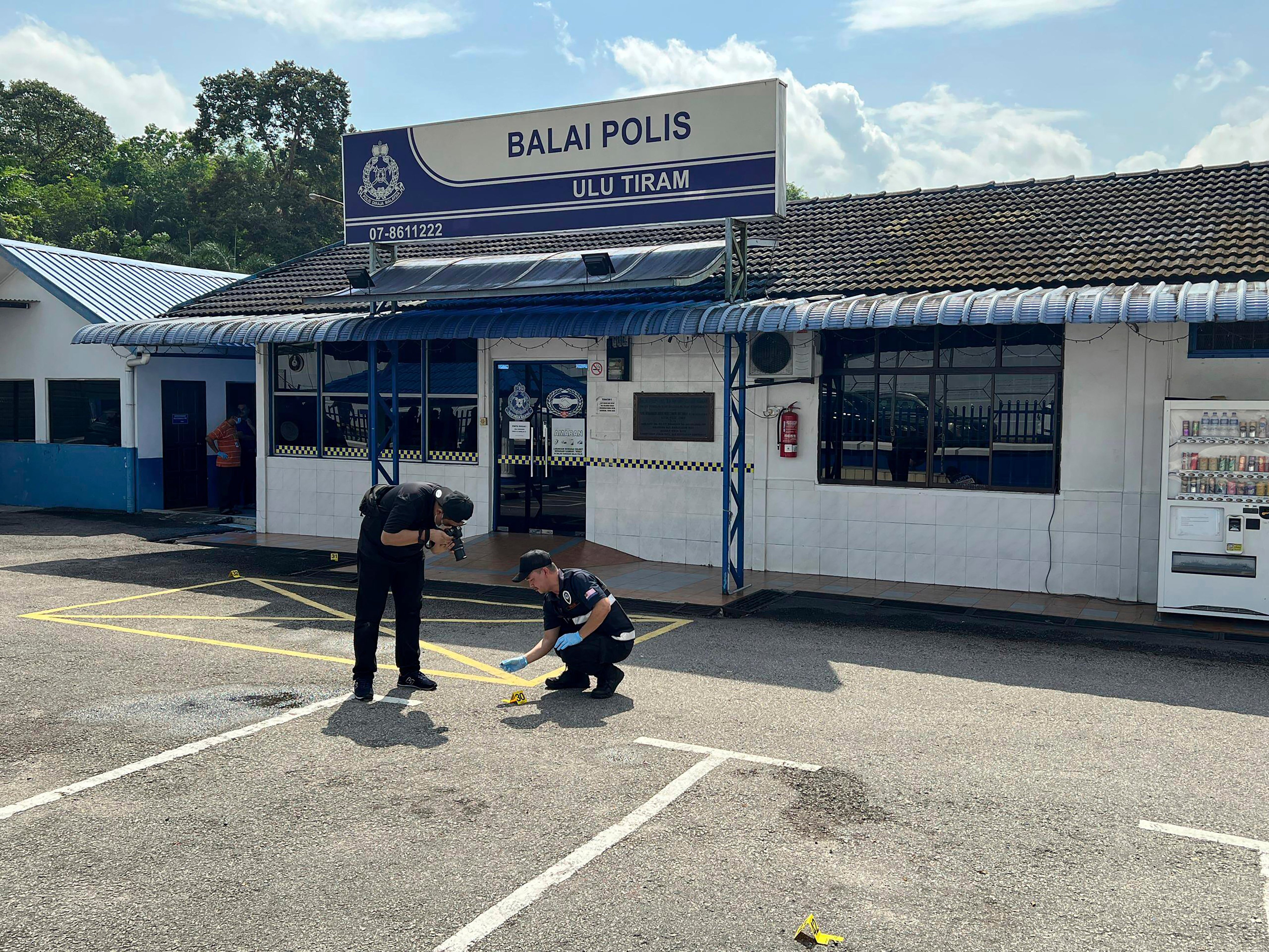 Forensic police officers outside Ulu Tiram station in Johor on May 17. Photo: AP