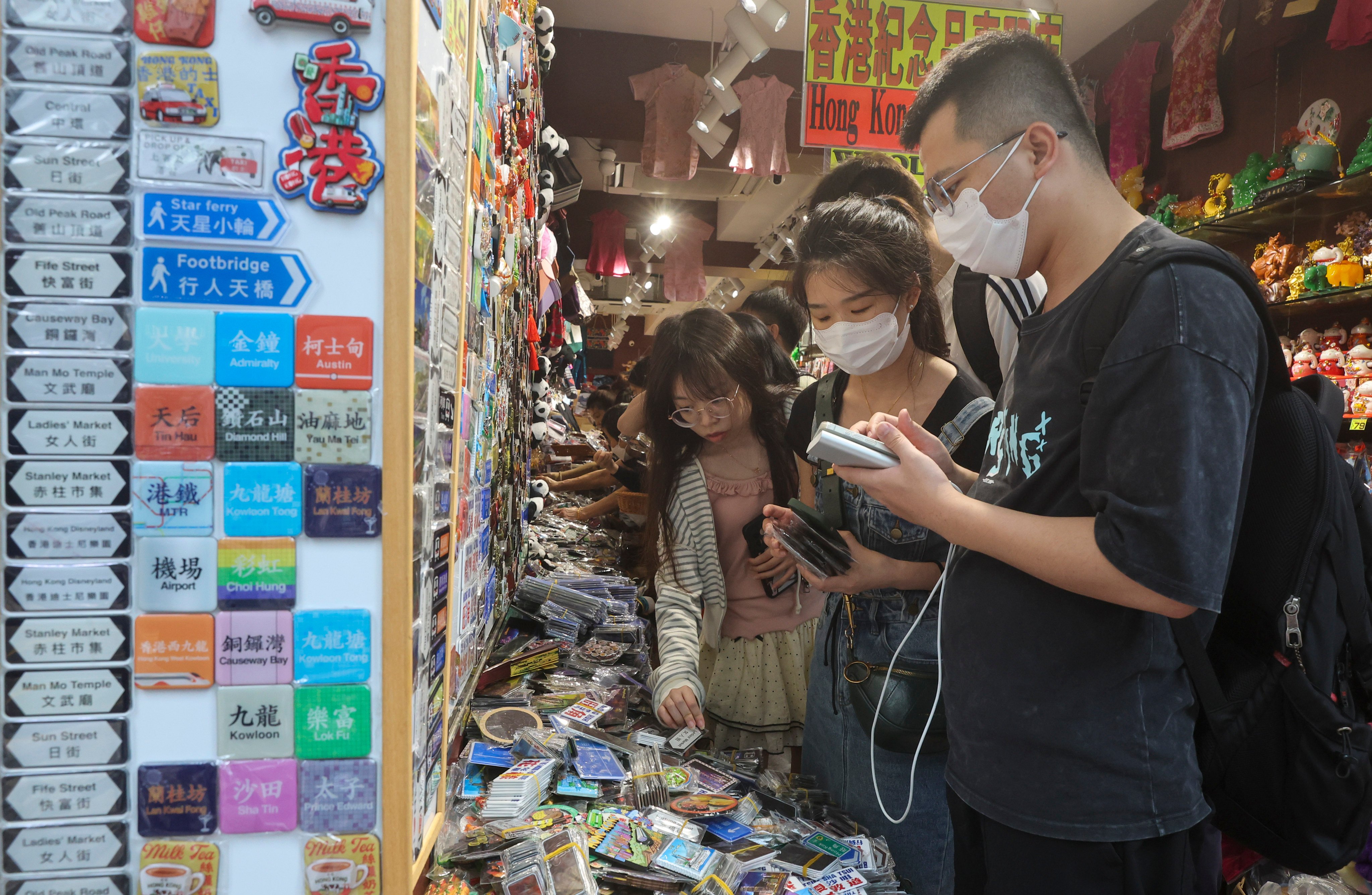 Tourists buy souvenirs in Tsim Sha Tsui. The city’s tourism sector could feel the impact of reduced spending by overnight visitors, according to a government forecast. Photo: Edmond So