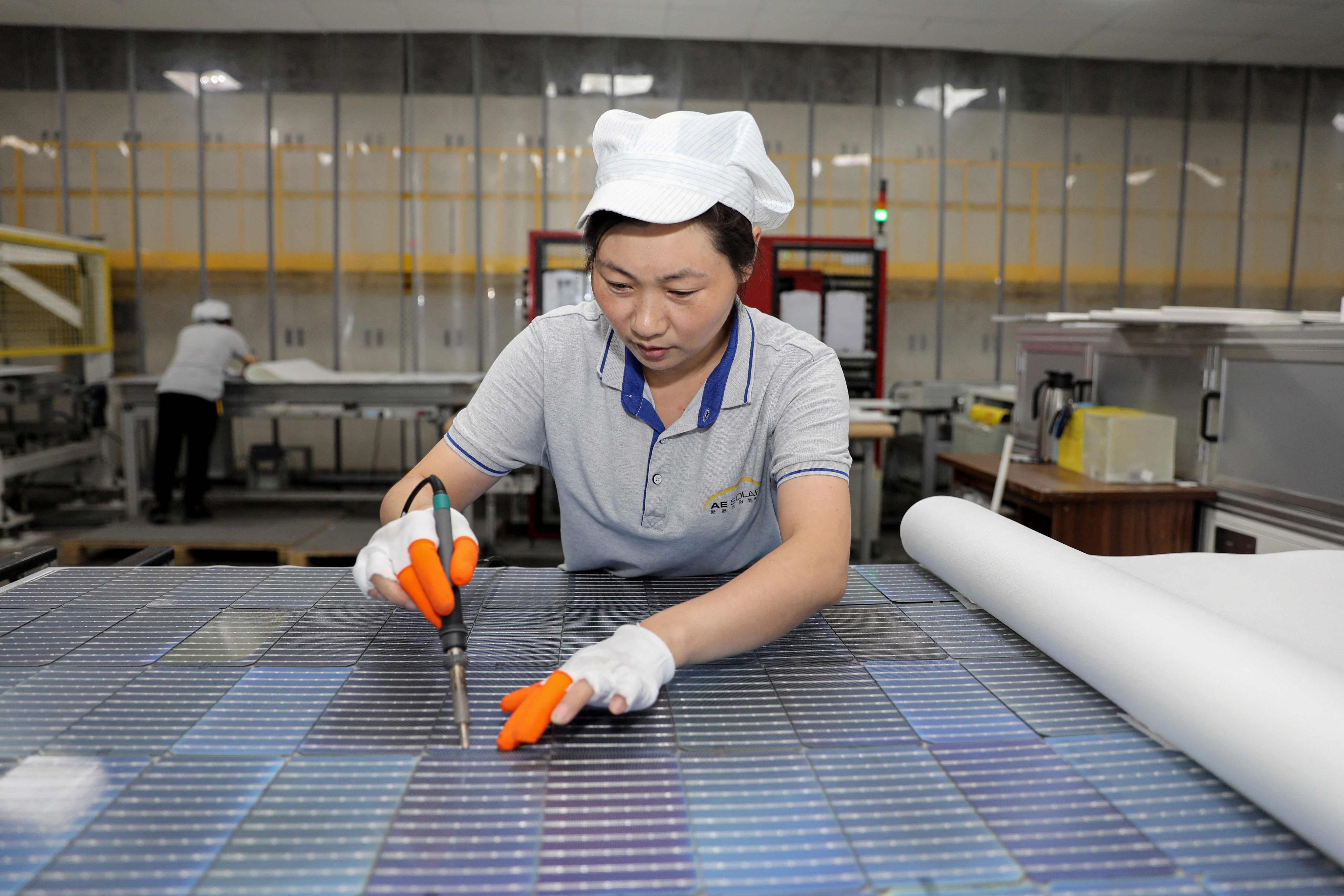 A worker produces solar photovoltaic modules used for solar panels at a factory in Huaian, Jiangsu province, on September 5, 2023. Photo: AFP