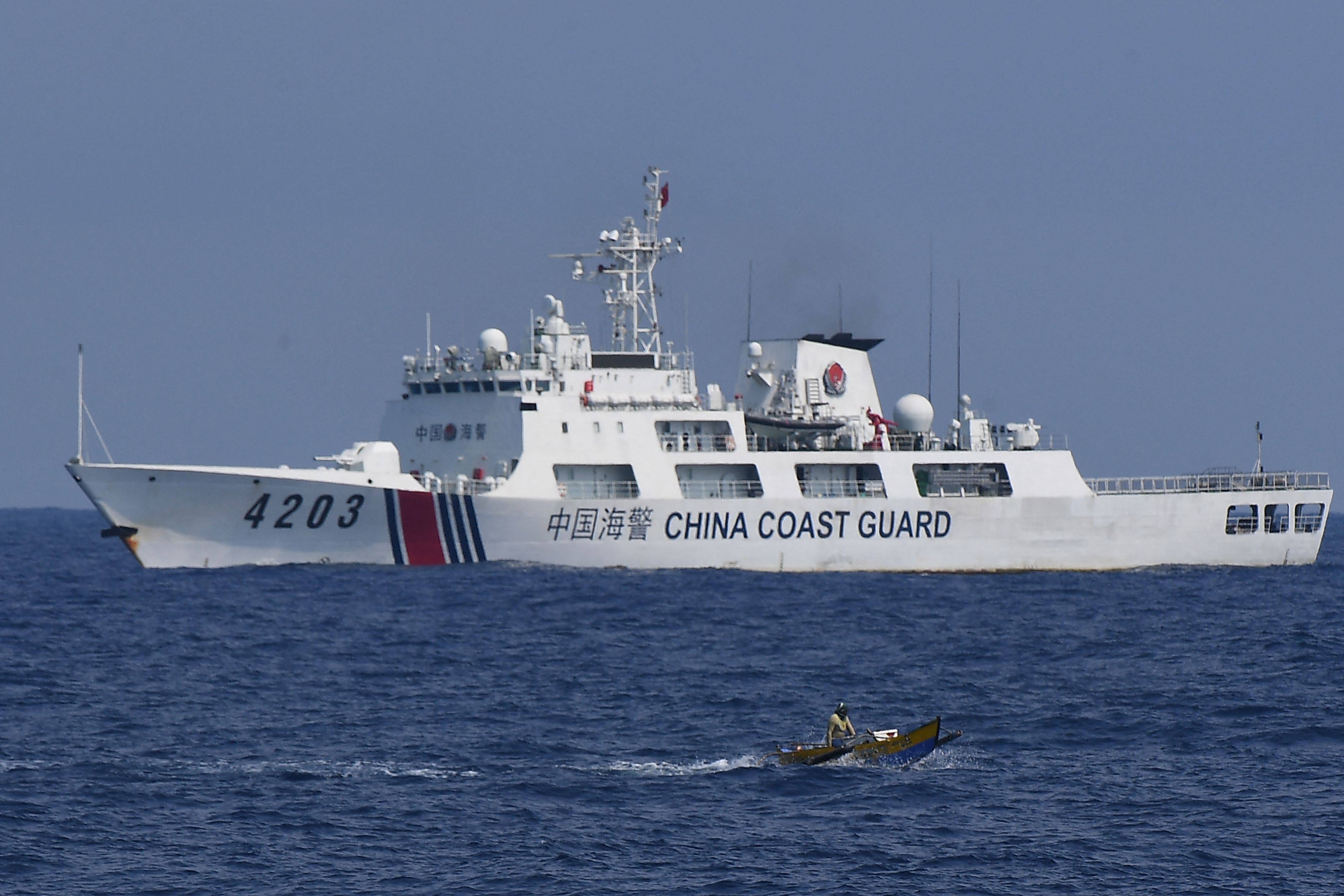 A Chinese coastguard ship monitors a Philippine fisherman in the disputed South China Sea on Thursday last week. Photo: AFP