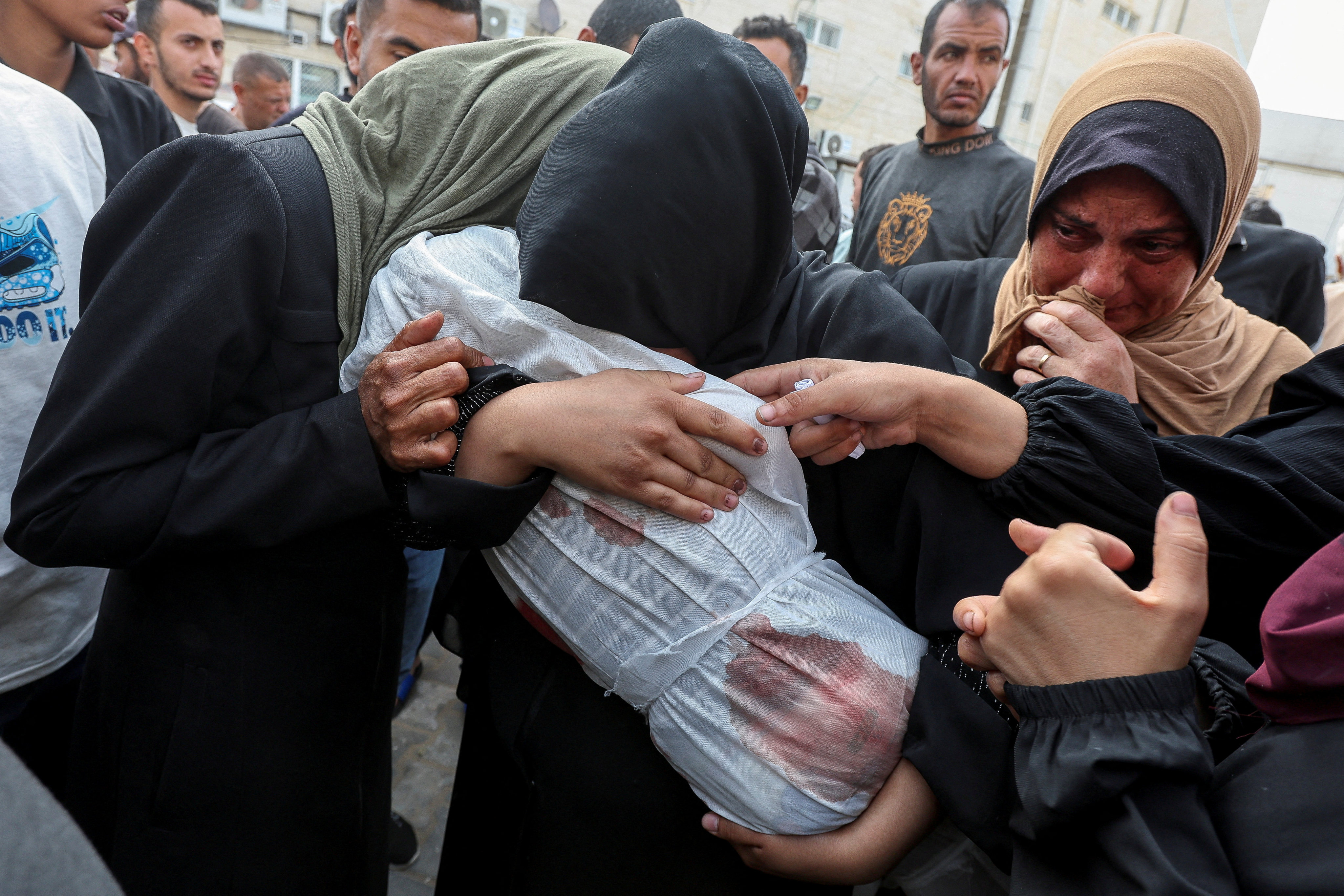 The mother and relatives of a Palestinian girl killed in an Israeli strike carry her body at Al-Aqsa hospital in Deir al-Balah, central Gaza on Sunday. Photo: Reuters 