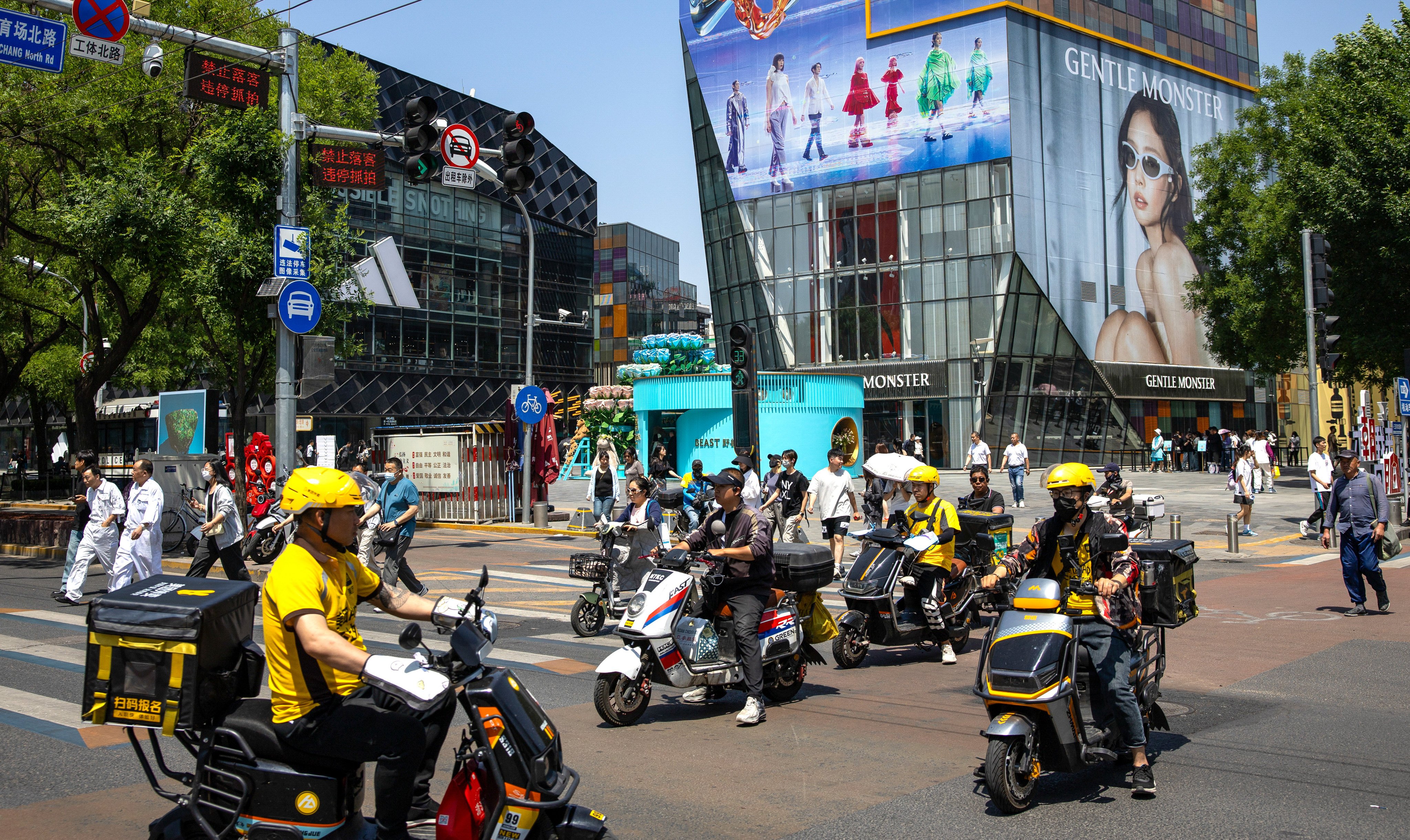 Riders and pedestrians negotiate an intersection in Beijing on May 17, 2024. Photo: EPA-EFE