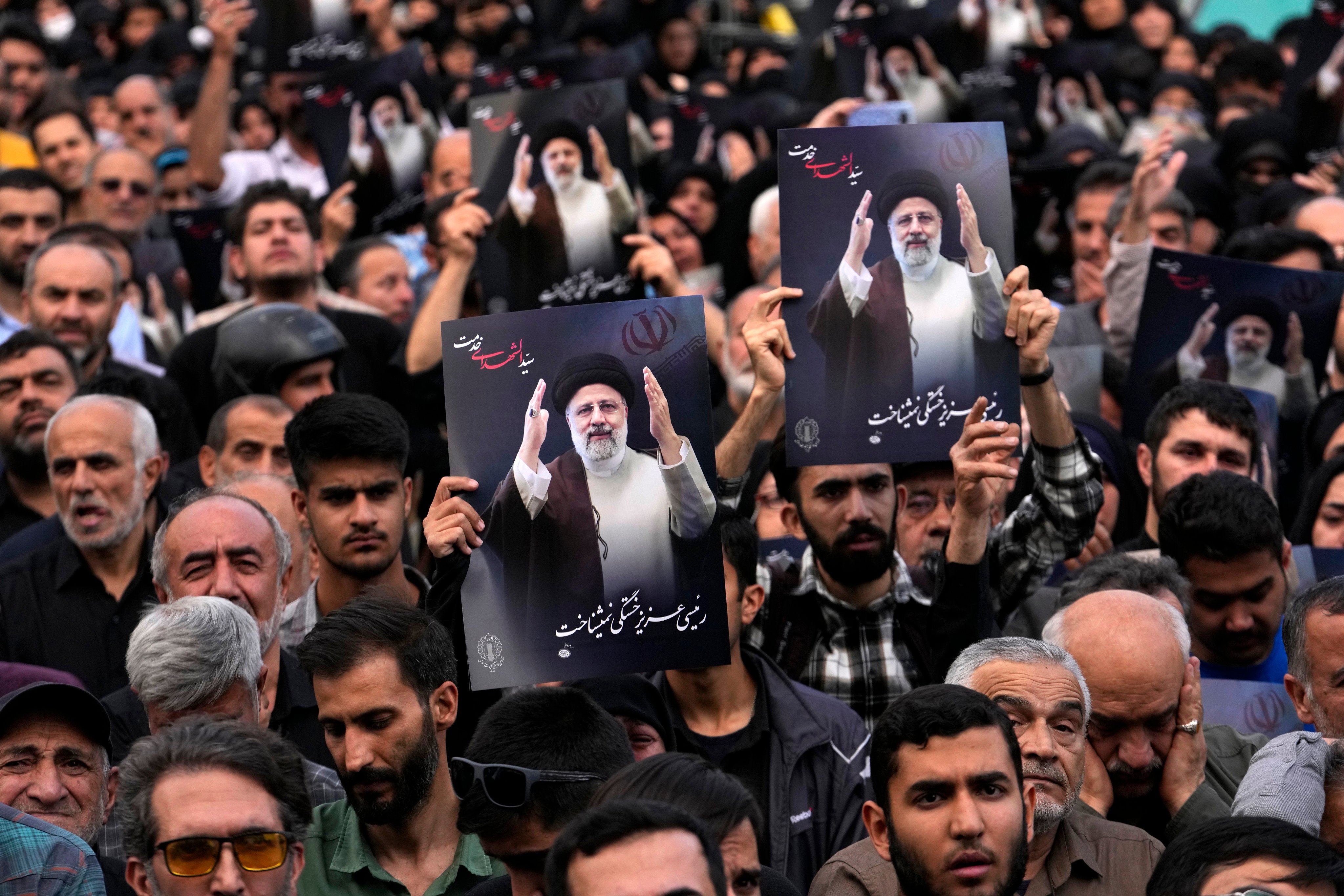 People hold up posters of President Ebrahim Raisi in downtown Tehran, Iran, on Monday. Photo: AP