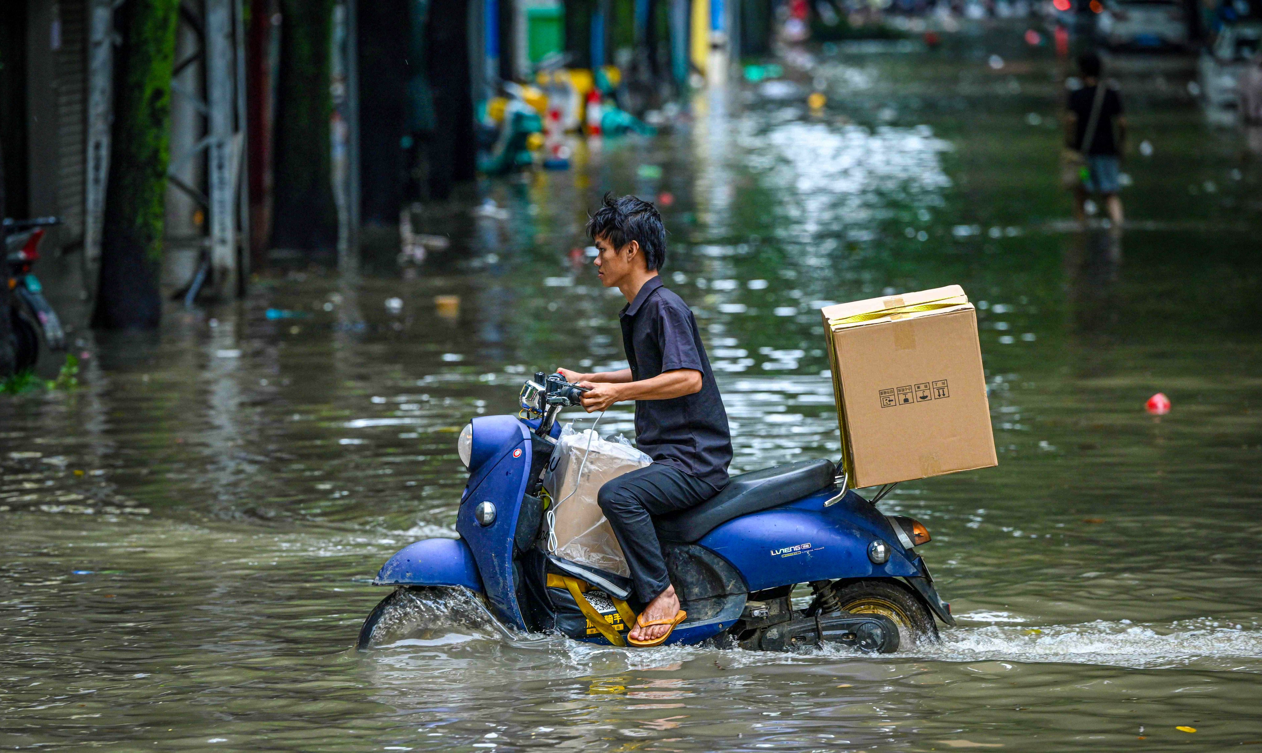 A man rides a scooter through a flooded street following heavy rain in Nanning, capital of south China’s Guangxi Zhuang autonomous region, on Sunday. Photo: AFP
