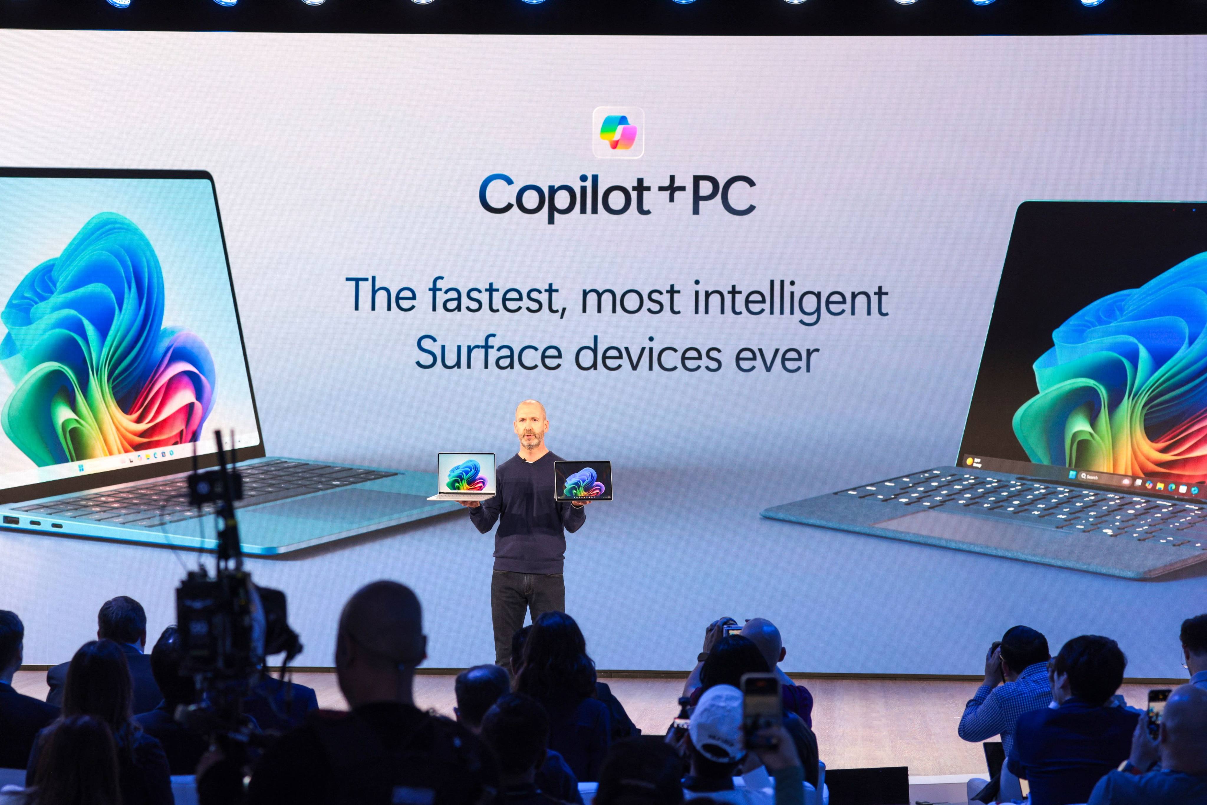 Microsoft vice-president of Surface devices Brett Ostrum held the company’s new AI PCs at an event in Redmond, Washington, on Monday. Photo: AFP