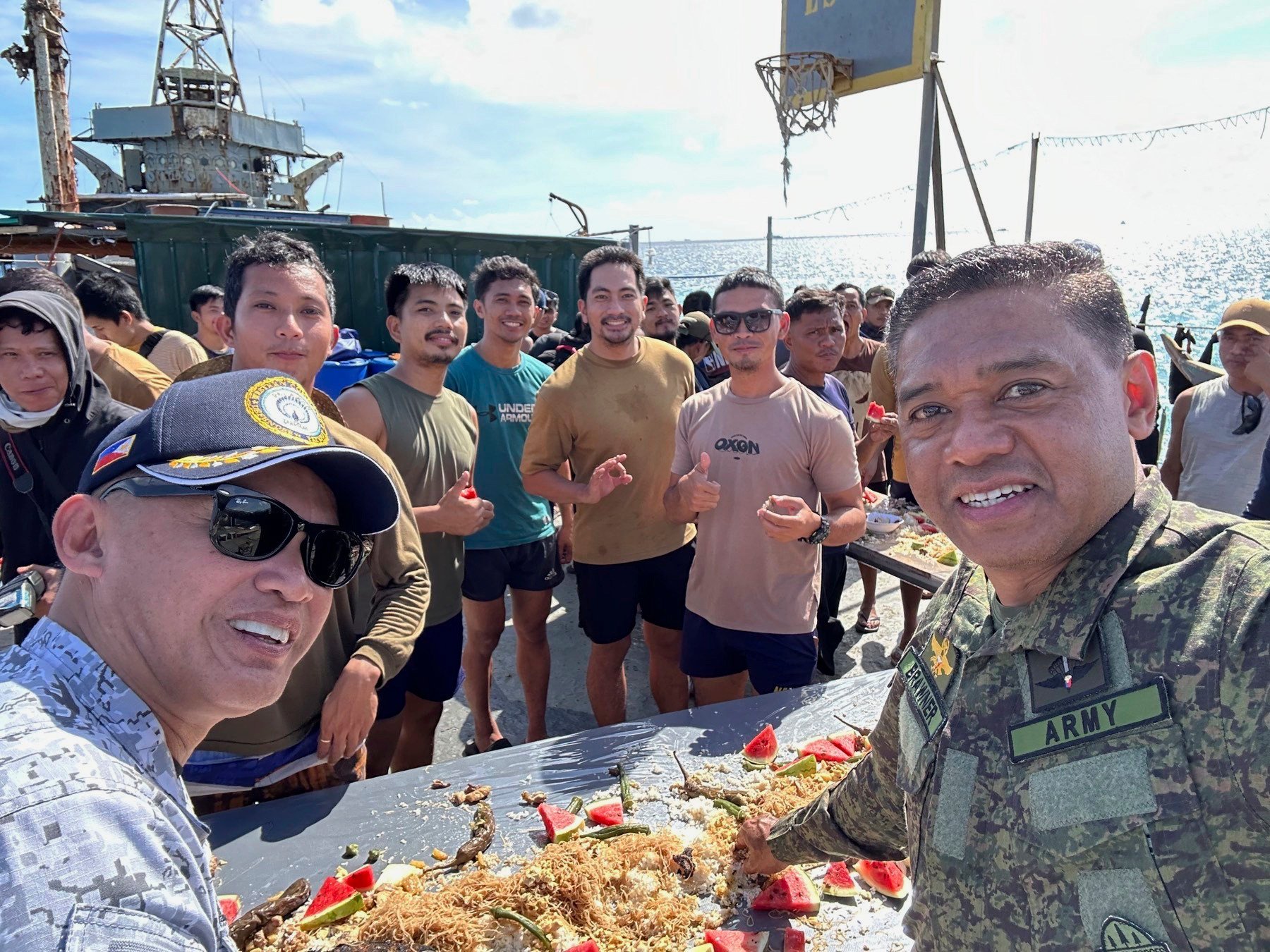 Philippine military chief Romeo Brawner Jnr (right) and Vice-Admiral Alberto Carlos (left) share a meal with Filipino marines and navy personnel stationed aboard the long-marooned BRP Sierra Madre at the Second Thomas Shoal in December 2023. Photo: Armed Forces of the Philippines PAO via AP