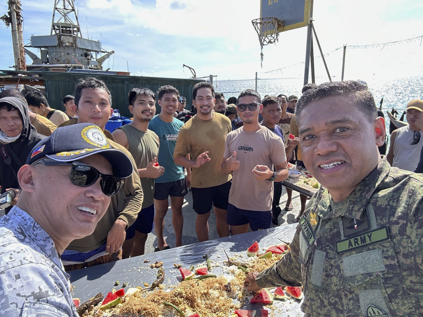 Philippine military chief Romeo Brawner Jnr (right) and Vice-Admiral Alberto Carlos (left) share a meal with Filipino marines and navy personnel stationed aboard the long-marooned BRP Sierra Madre at the Second Thomas Shoal in December 2023. Photo: Armed Forces of the Philippines PAO via AP