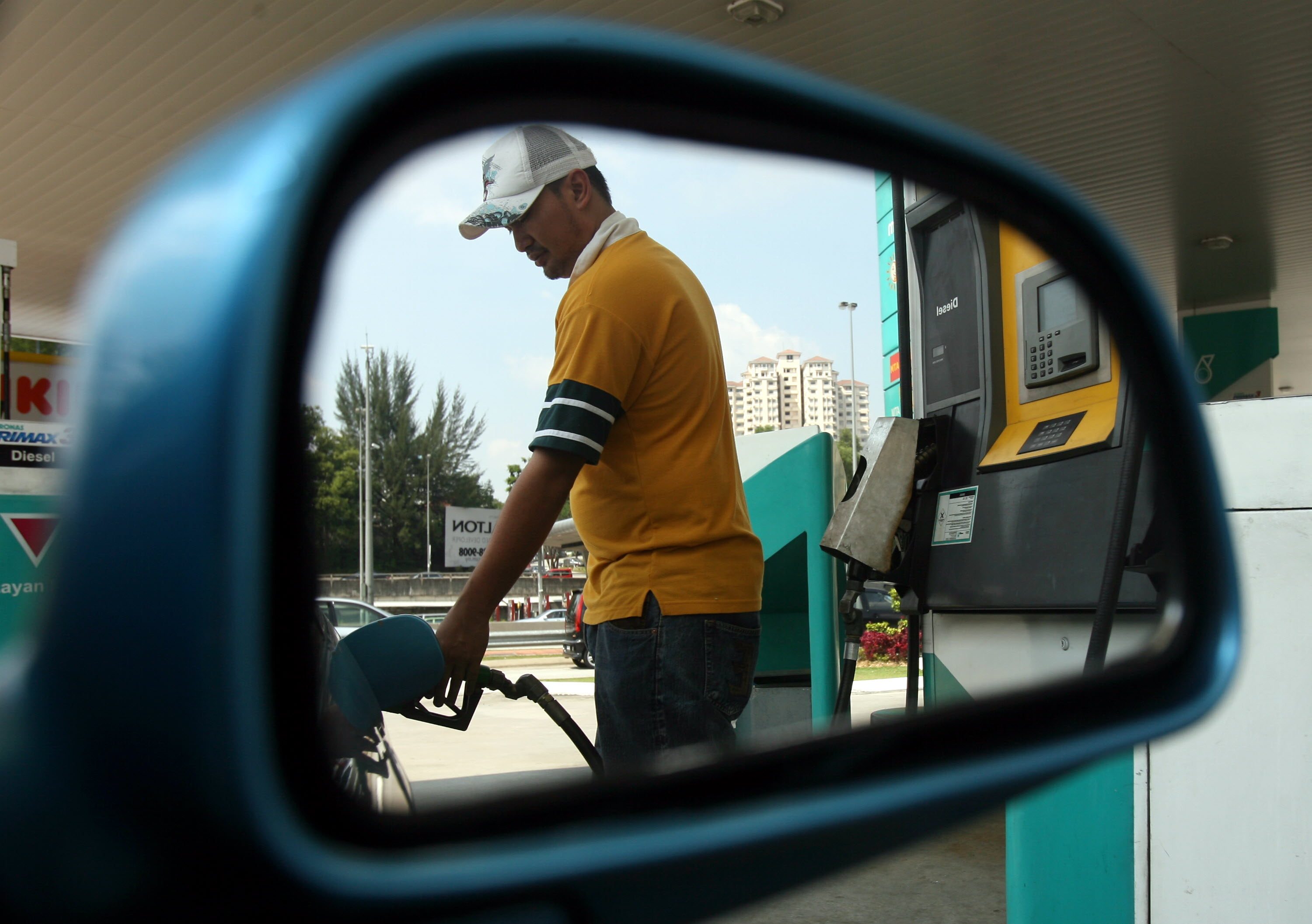 A man fills the tank of a car at a petrol station in Kuala Lumpur. Photo: AFP