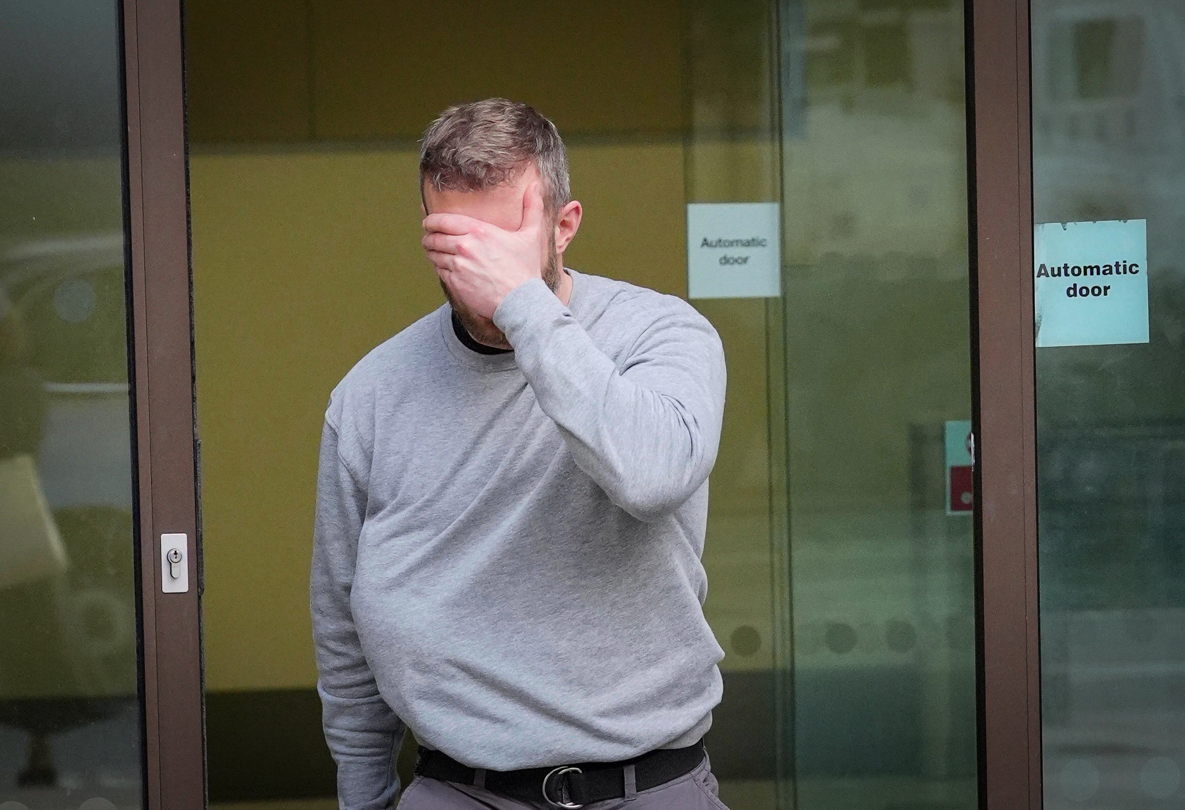Matthew Trickett covers his face as he leaves Westminster Magistrates’ Court in London on May 13. Photo: PA via AP