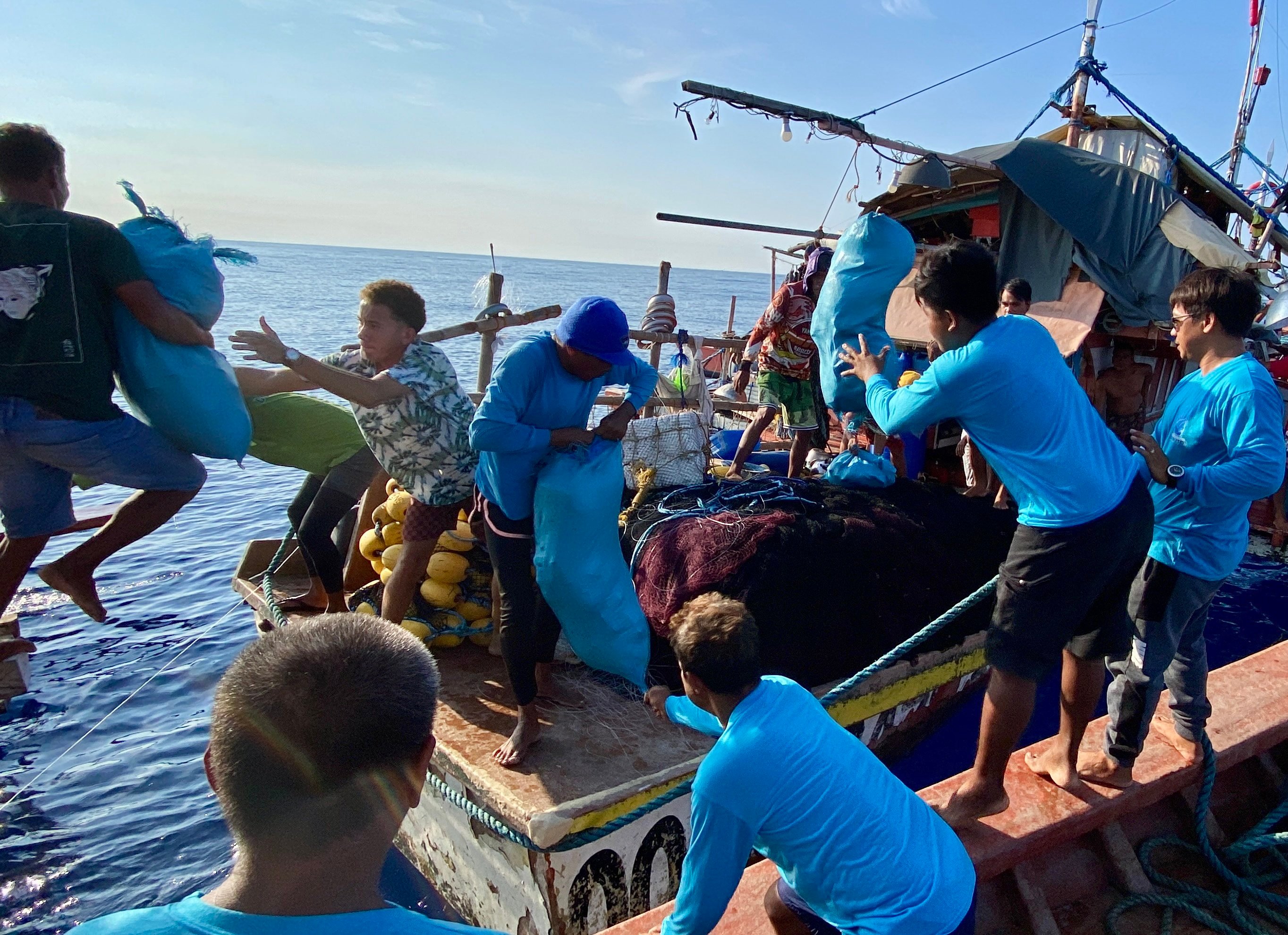 Filipino fishermen receiving supplies from volunteers near Scarborough Shoal in the disputed South China Sea. Photo: EPA-EFE