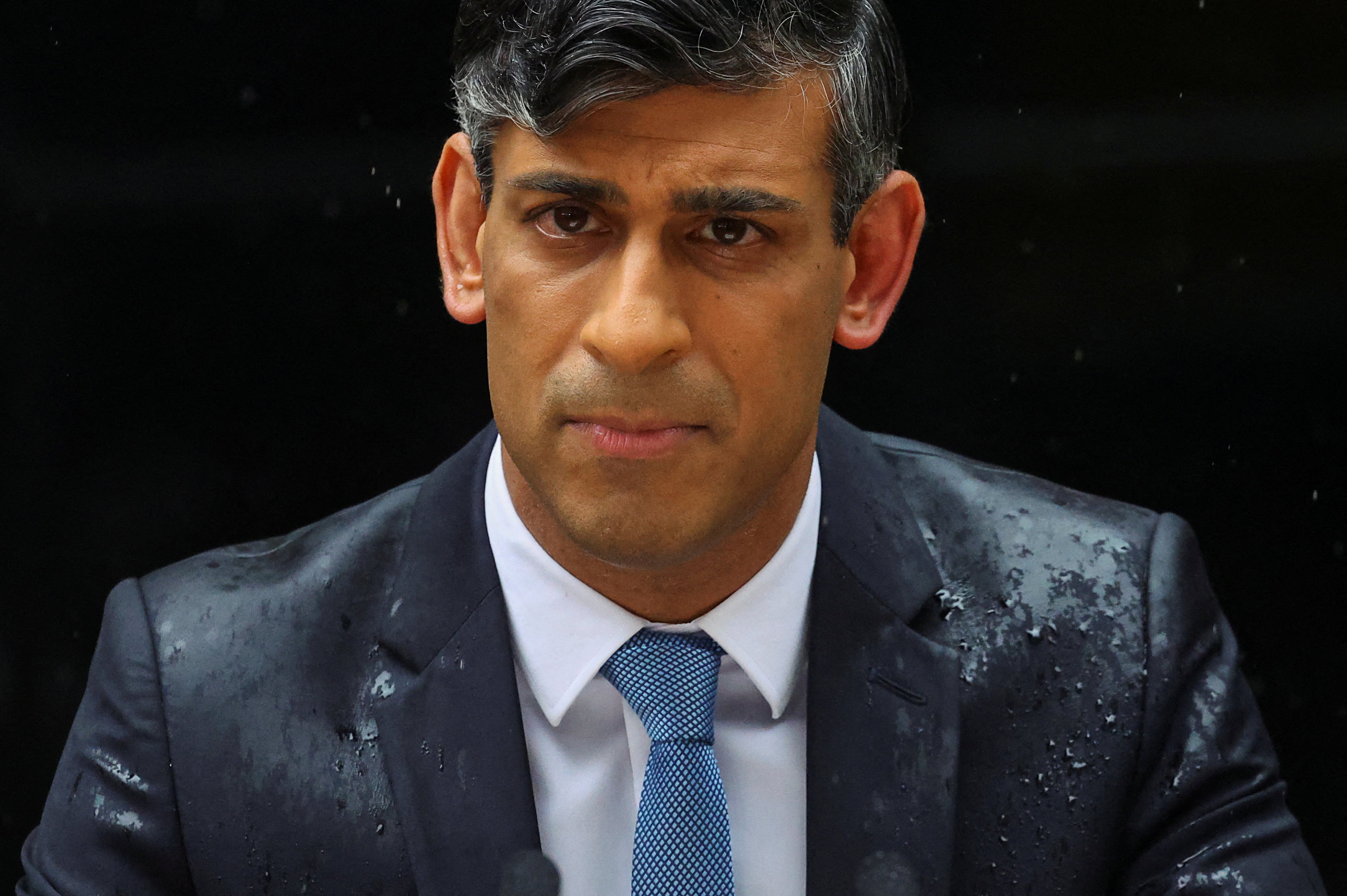 Rain-soaked Rishi Sunak announcing the UK election date. Photo: Reuters