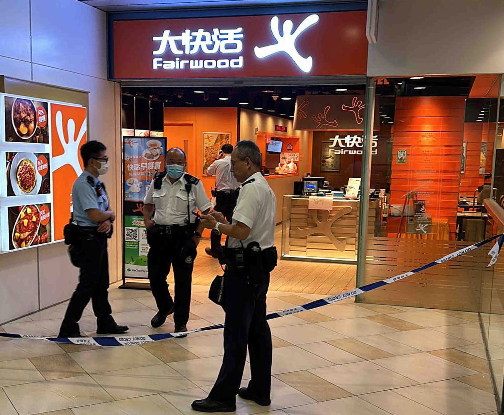 Transeúntes ayudan a someter a un cuchillo en un establecimiento de comida rápida en un centro comercial de Hong Kong
