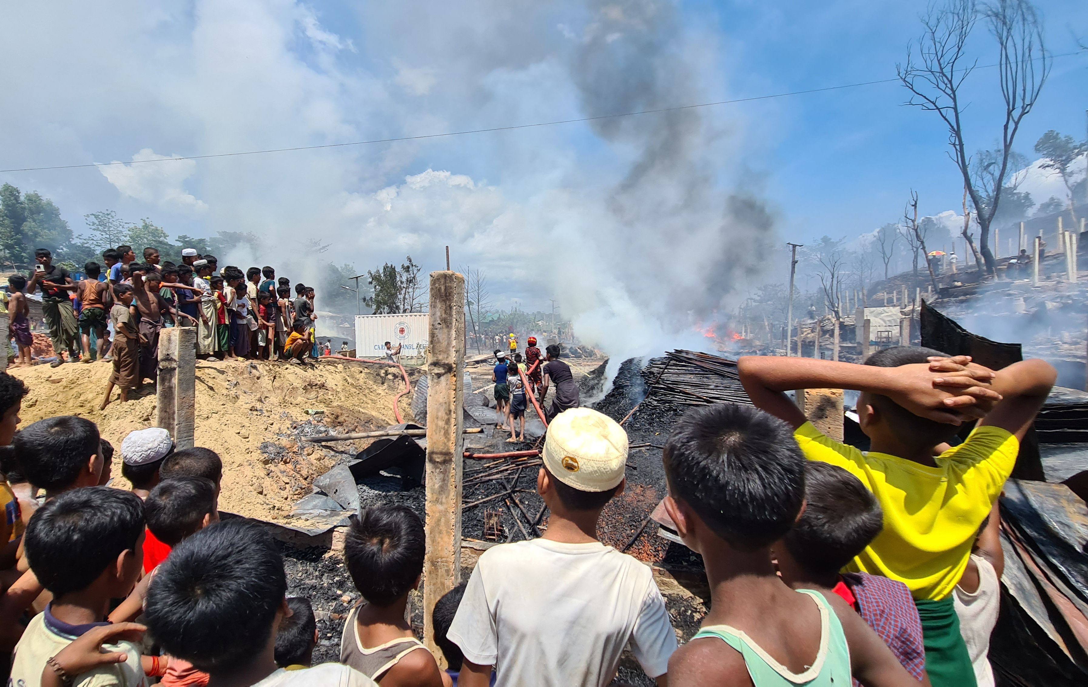 Rohingya refugees look through the debris of their houses charred by a fire at a camp in Cox’s Bazar. Photo: AFP