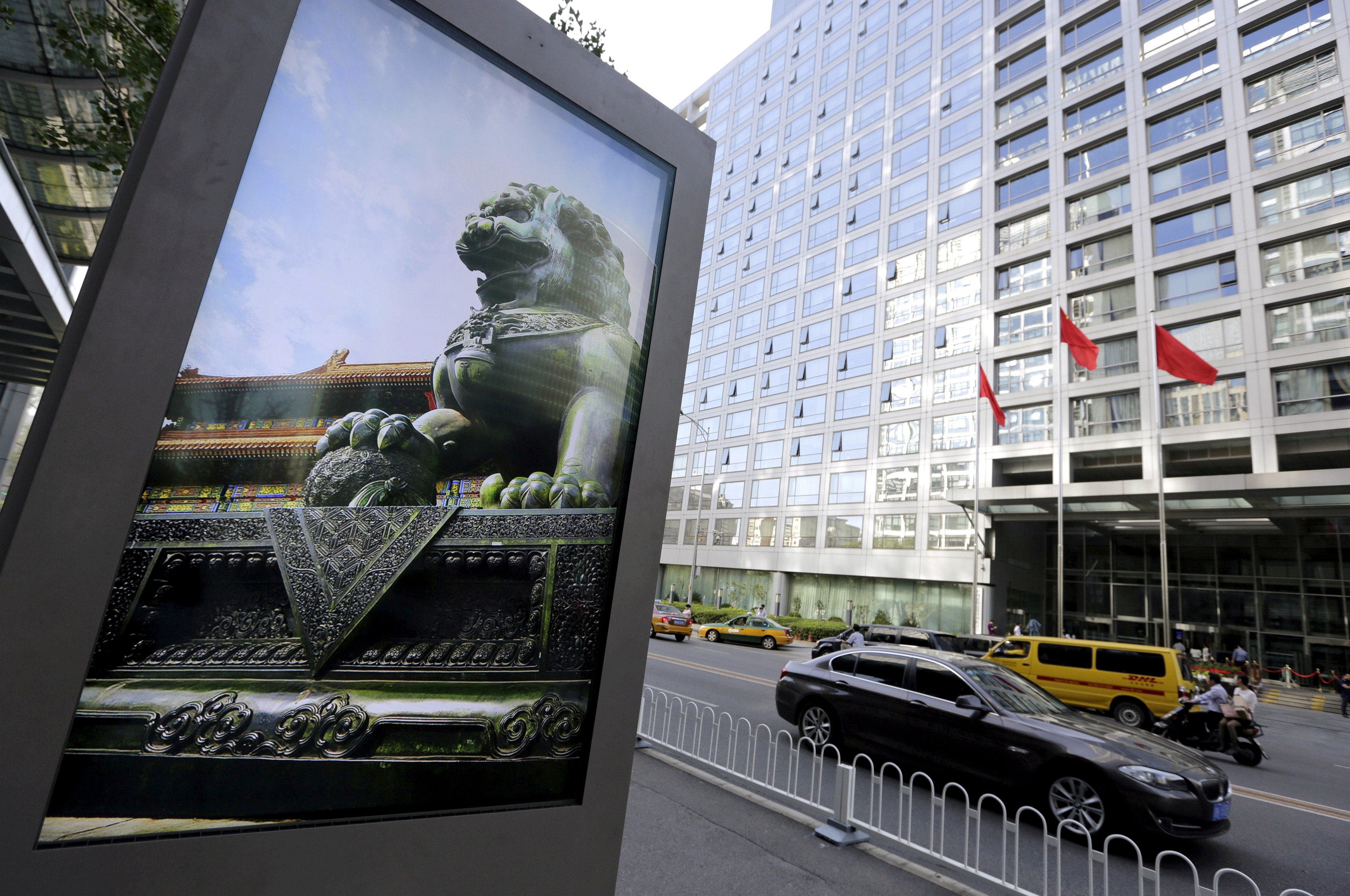 A stone lion appears on an advertising board near the headquarters of the China Securities Regulatory Commission in Beijing. Photo: Reuters