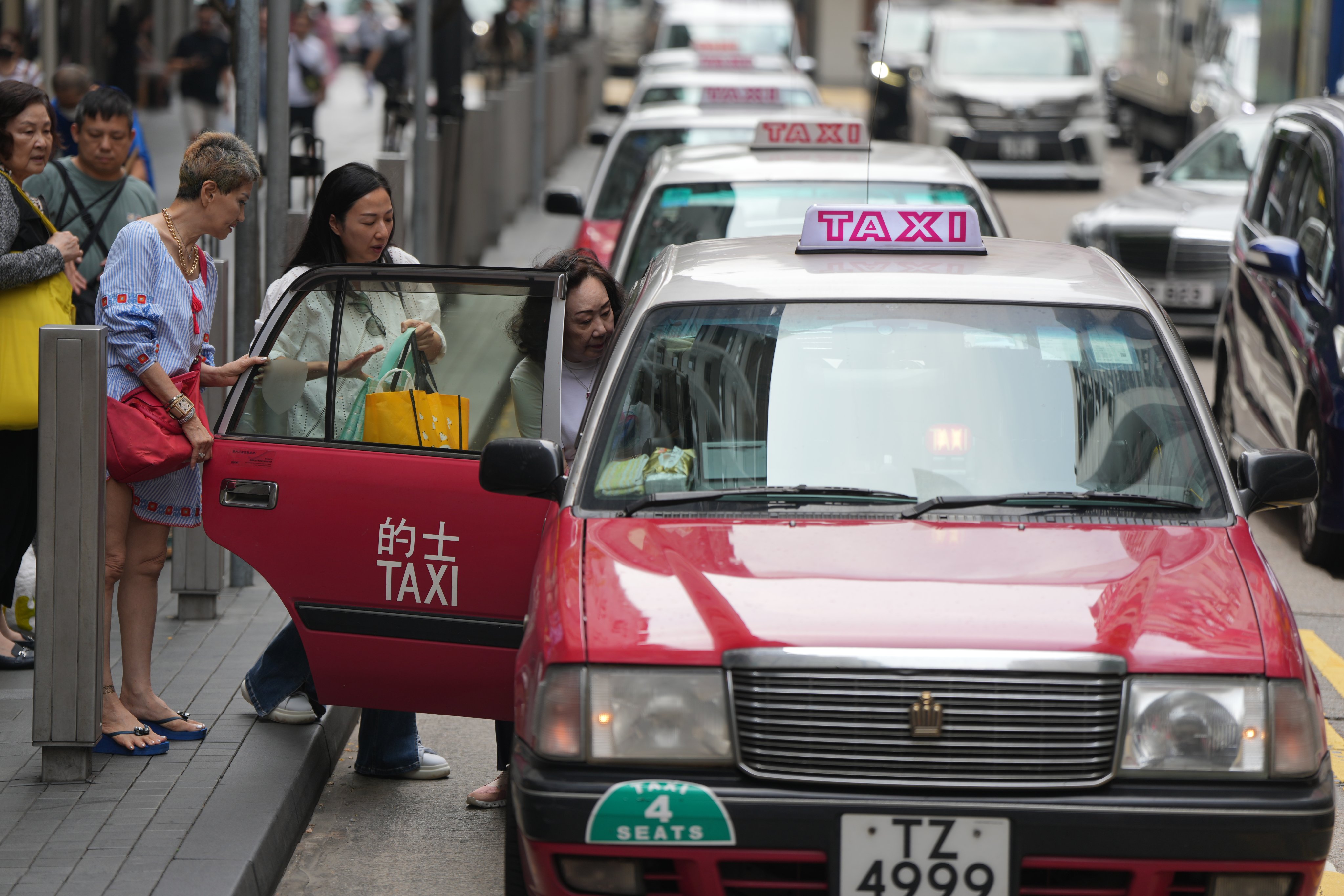 Passengers get into taxis in Causeway Bay on May 7. Both the taxi industry and ride-hailing services such as Uber ought to be better regulated. Photo: Sam Tsang