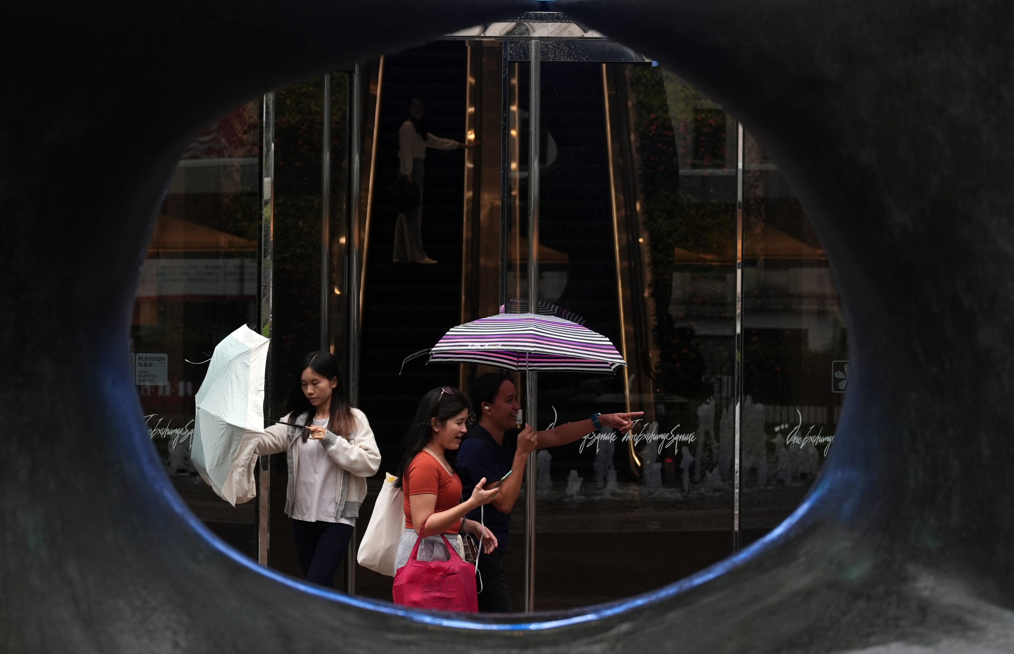Pedestrians walk past Exchange Sqaure in Central under rainy and gusty conditions. Photo: Eugene Lee