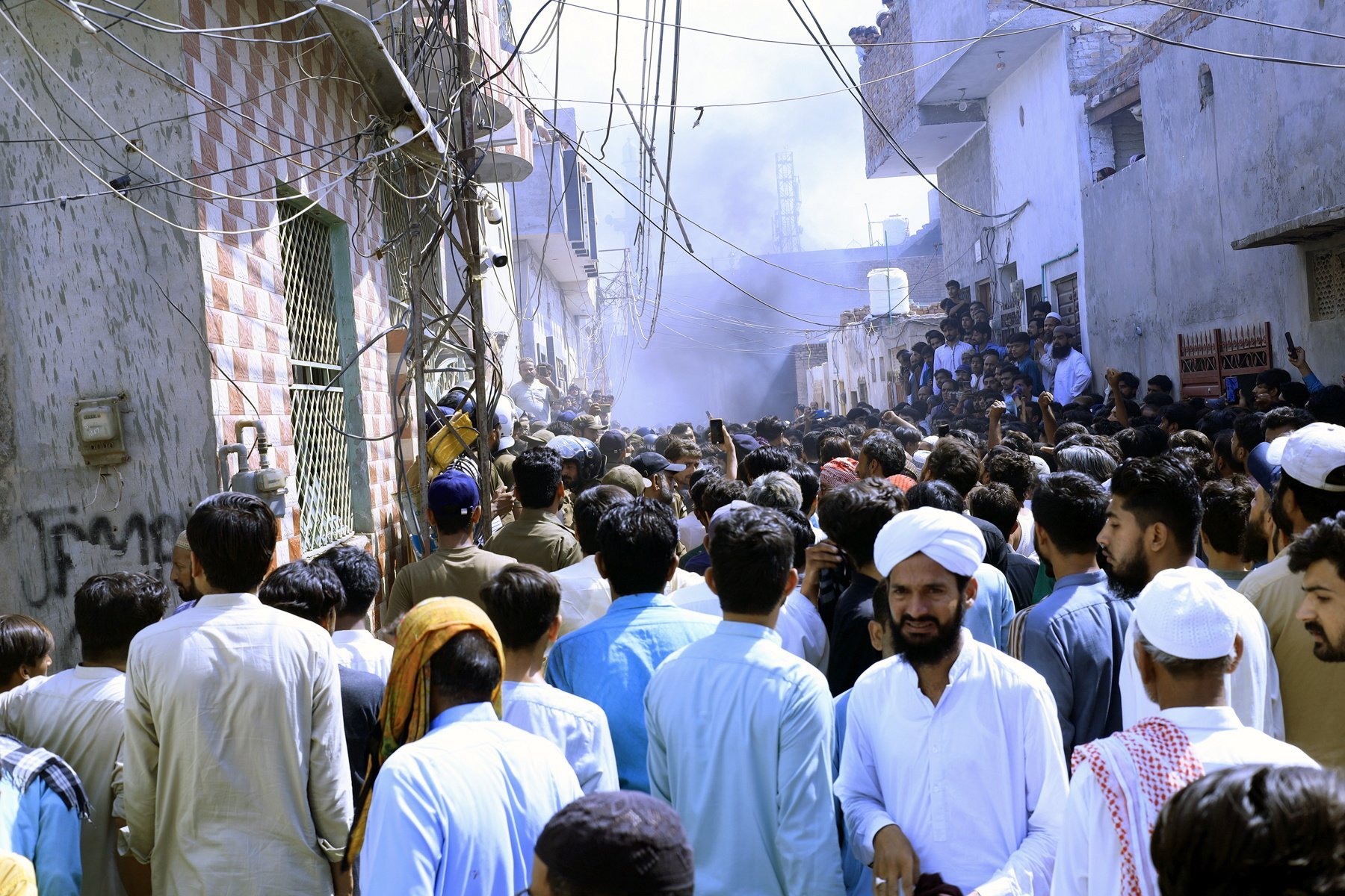 People gather at the scene after a violent mob attacked a Christian community over alleged blasphemy in Sargodha, Pakistan. Photo: EPA-EFE