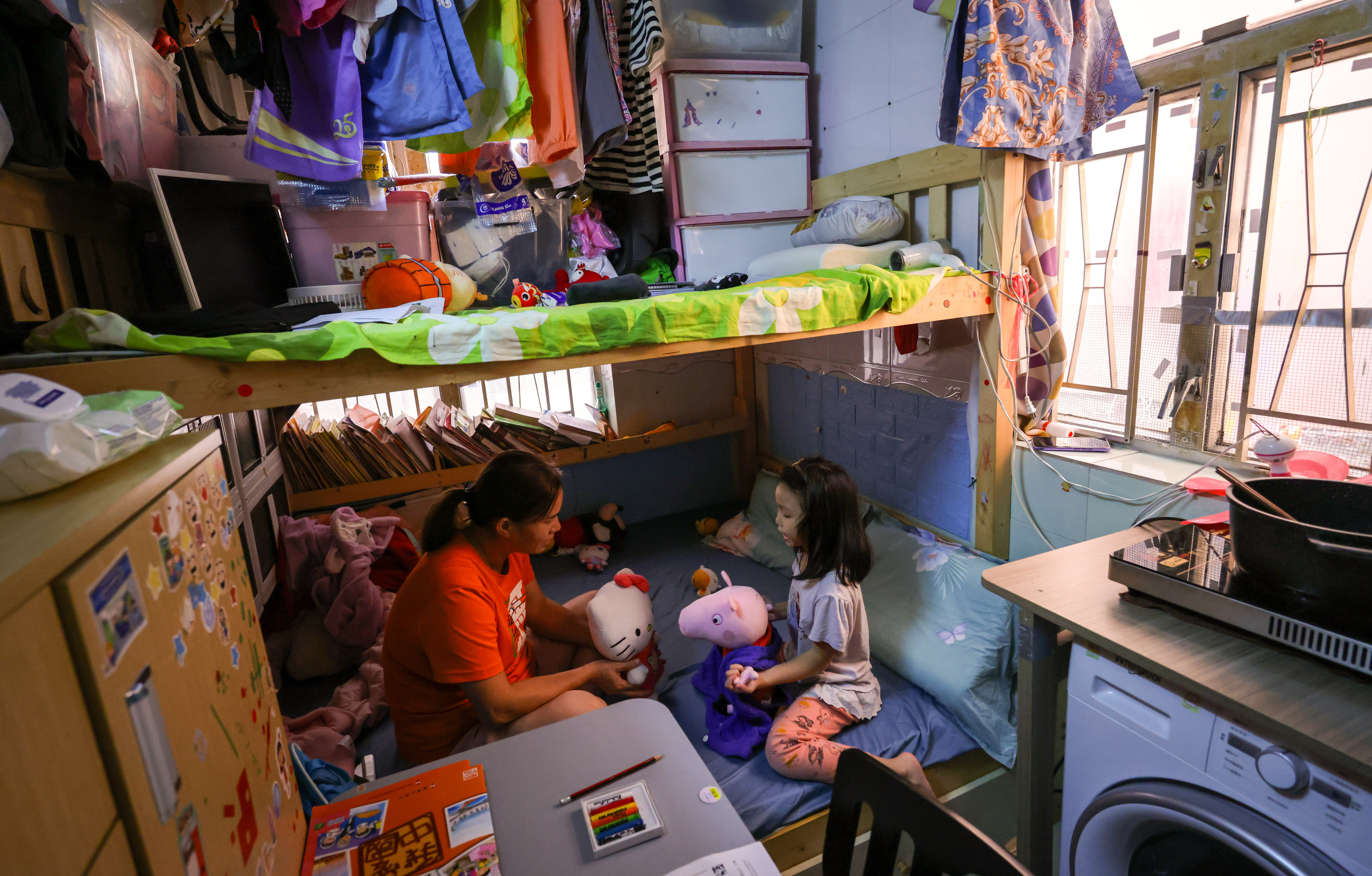 A single mother and her five-year-old daughter in their home in Sham Shui Po. The NGO poll found the median price for a subdivided studio flat was HK$4,300. Photo: May Tse