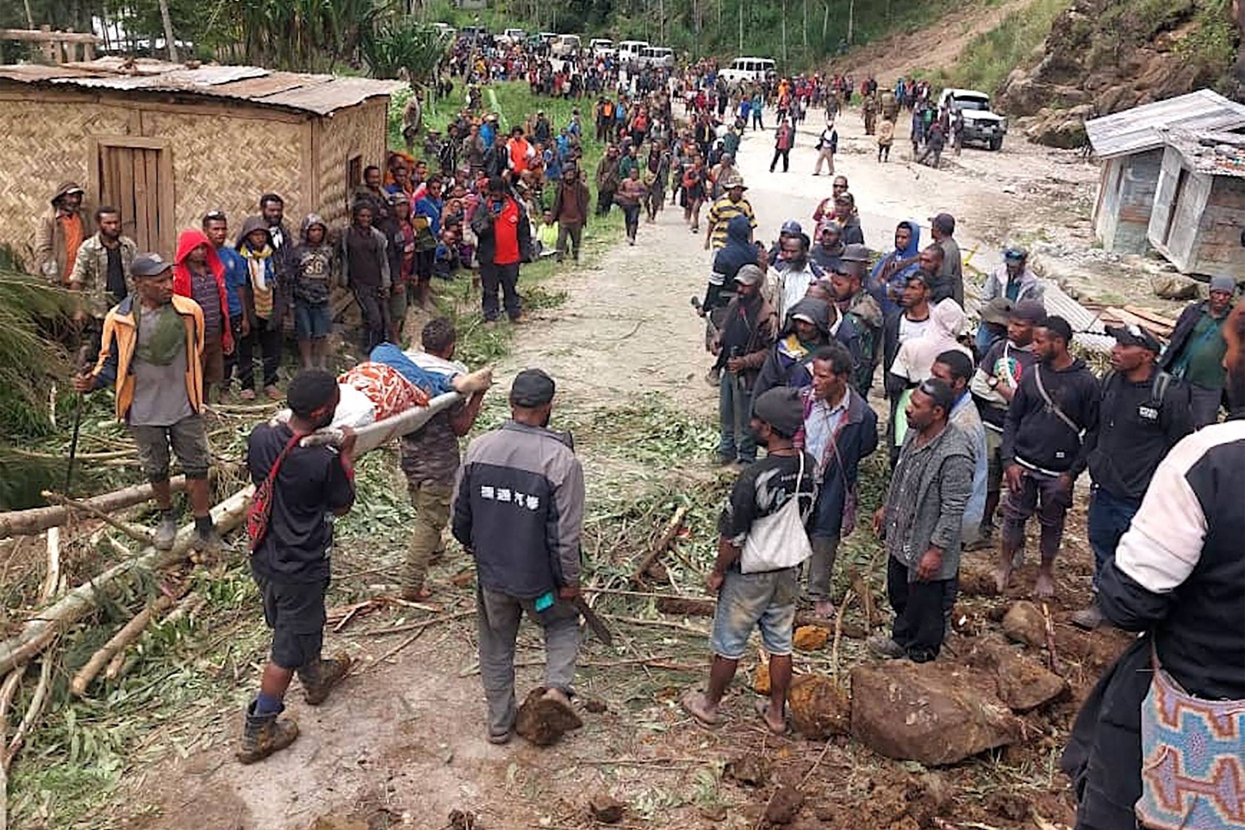 Locals carry a person on a stretcher from the site of a landslide at Yambali village in Papua New Guinea’s Enga province on May 25. Photo: IOM/AFP