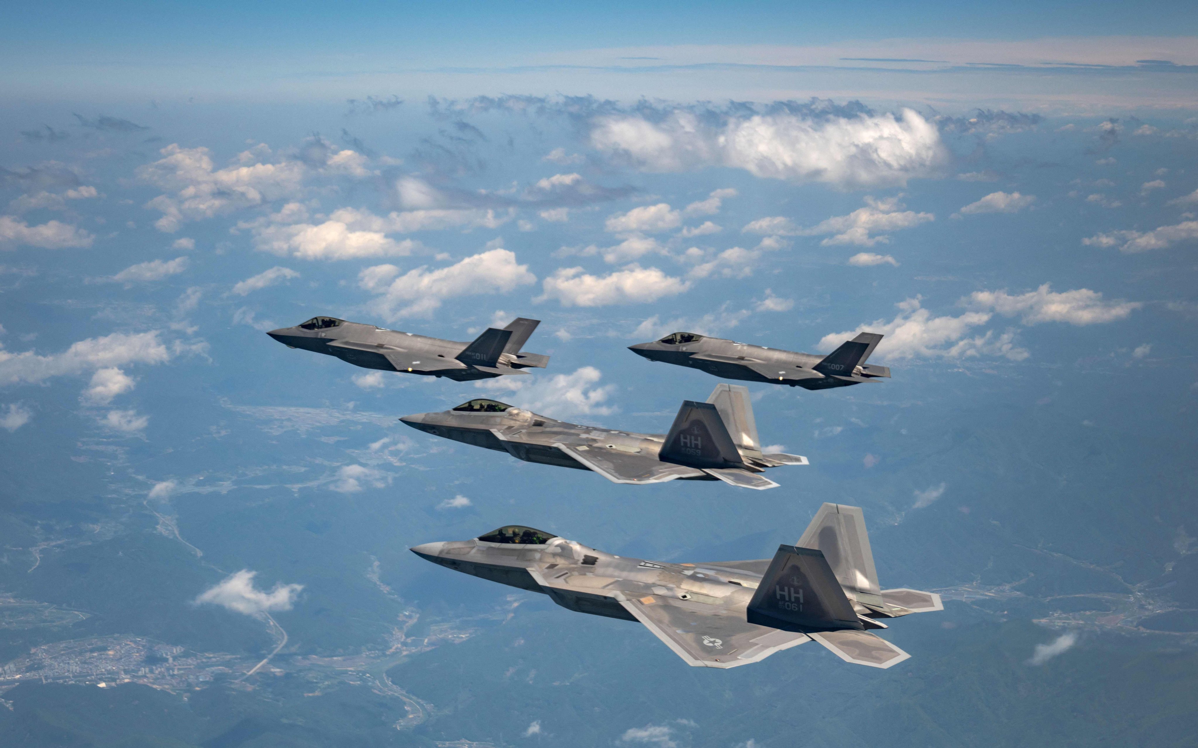 Two US Air Force F-22 fighter jets (front) fly with two South Korean Air Force F-35A fighter jets during a joint air drill in South Korea. Photo: Handout / South Korean Defence Ministry / AFP