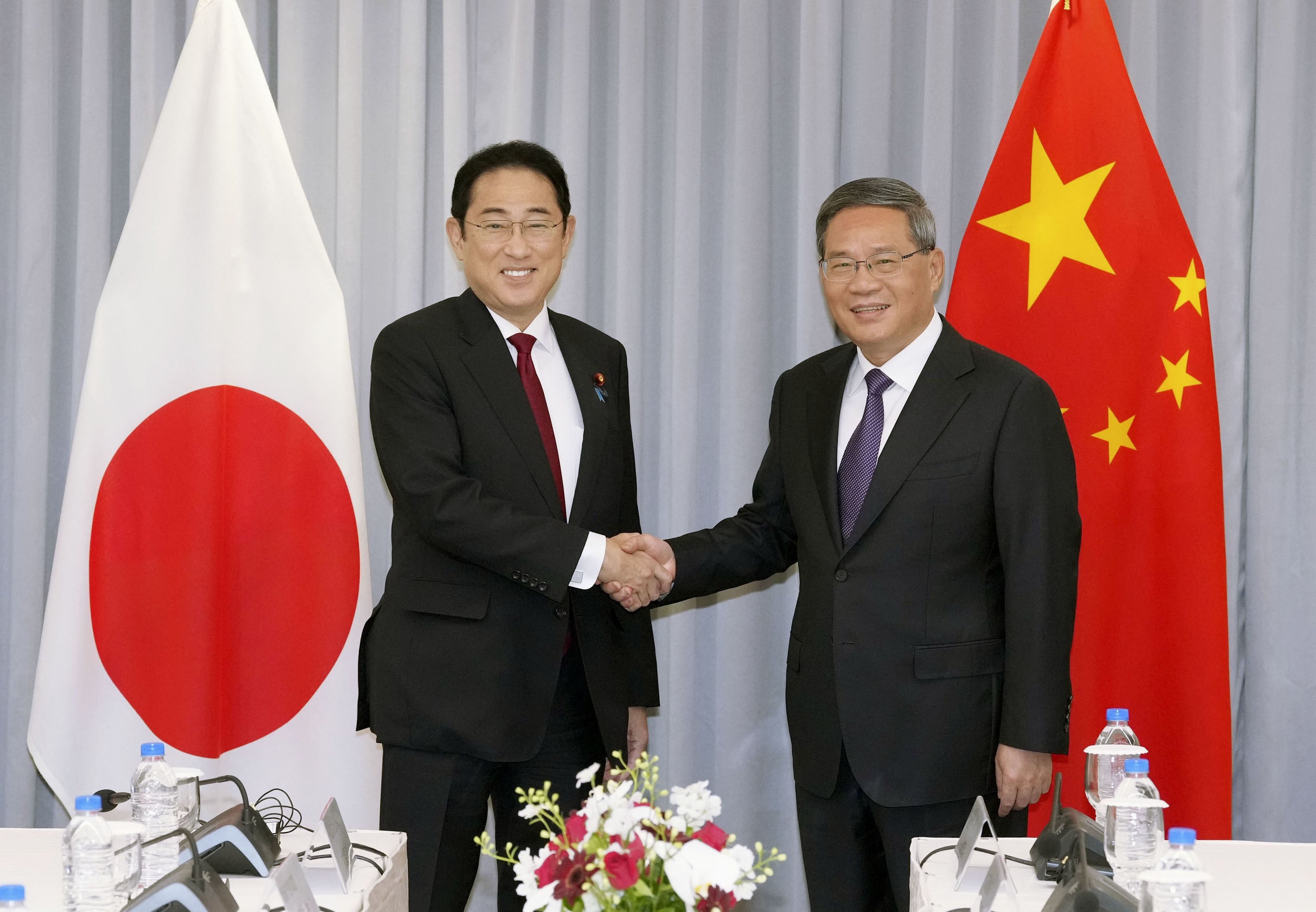 Chinese Premier Li Qiang and Japanese Prime Minister Fumio Kishida ahead of their first official meeting, in Seoul on Sunday. Photo: Kyodo