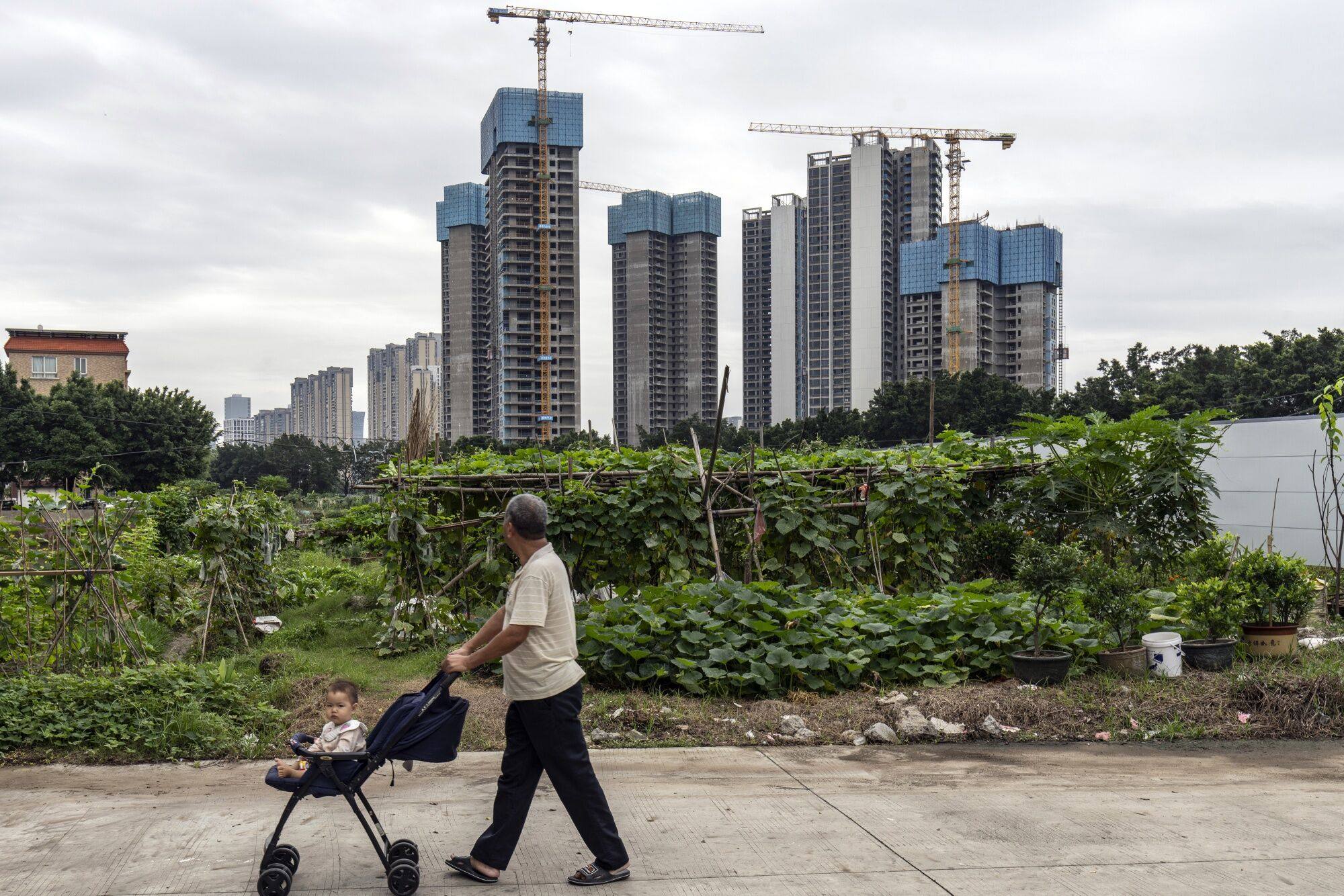 A pedestrian wheels a baby past residential buildings under construction at Country Garden’s Century Centre development in Foshan, Guangdong province, on May 22. The central government has taken several measures to ease the crisis in China’s property market, generating an upsurge in sentiment around Chinese stocks. Photo: Bloomberg