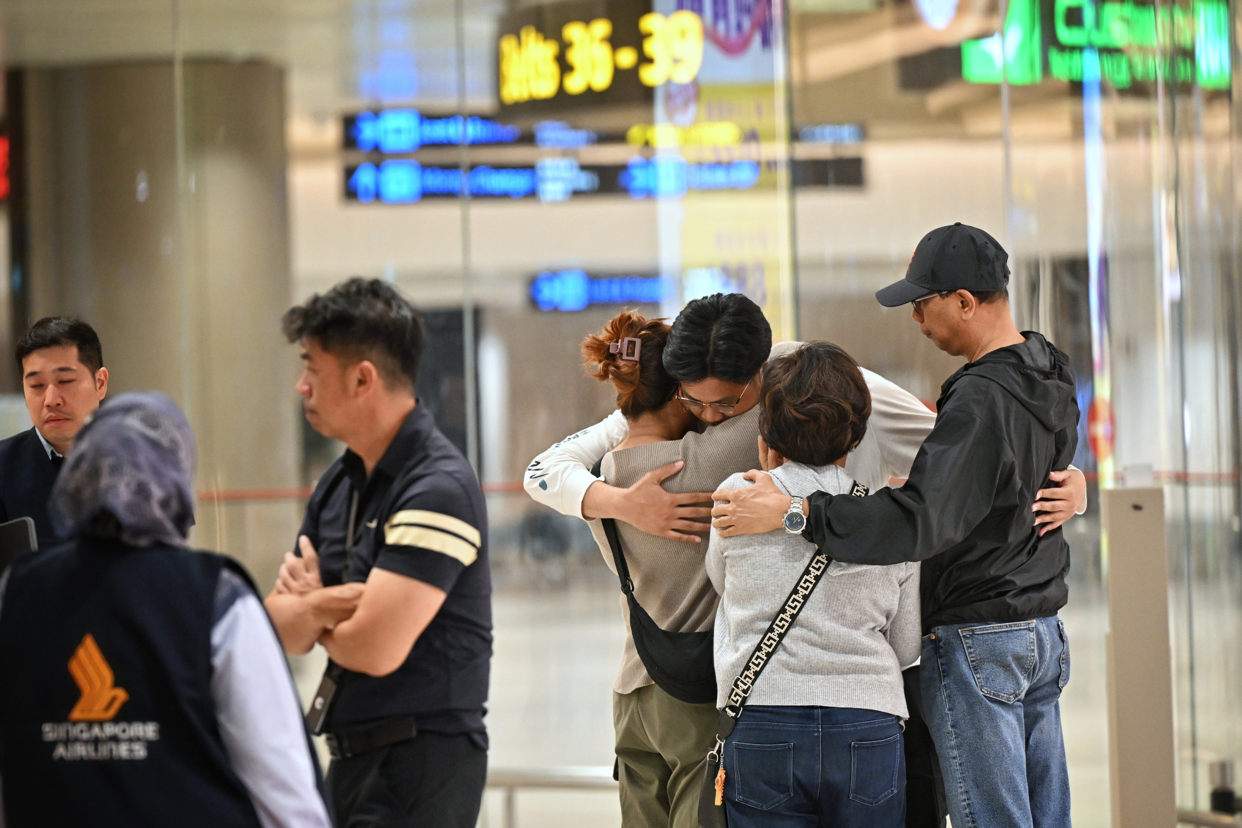 People who travelled on the Singapore Airlines flight SQ321, which made an emergency landing in Bangkok after encountering severe turbulence, greet family upon arrival at Changi Airport in Singapore on May 22. Photo: EPA-EFE