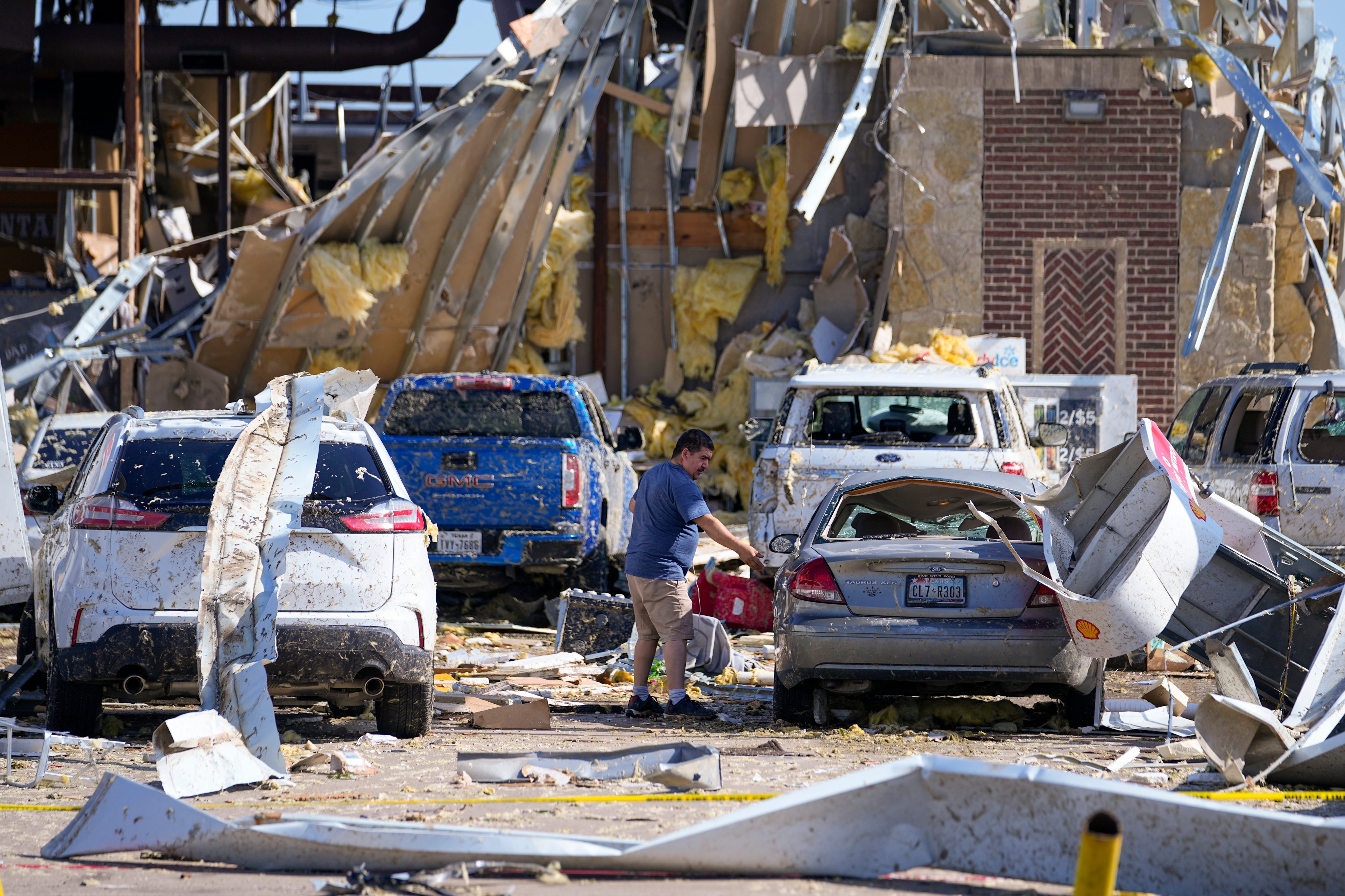 A man looks at a damaged car after a tornado hit in Valley View, Texas. Photo: AP