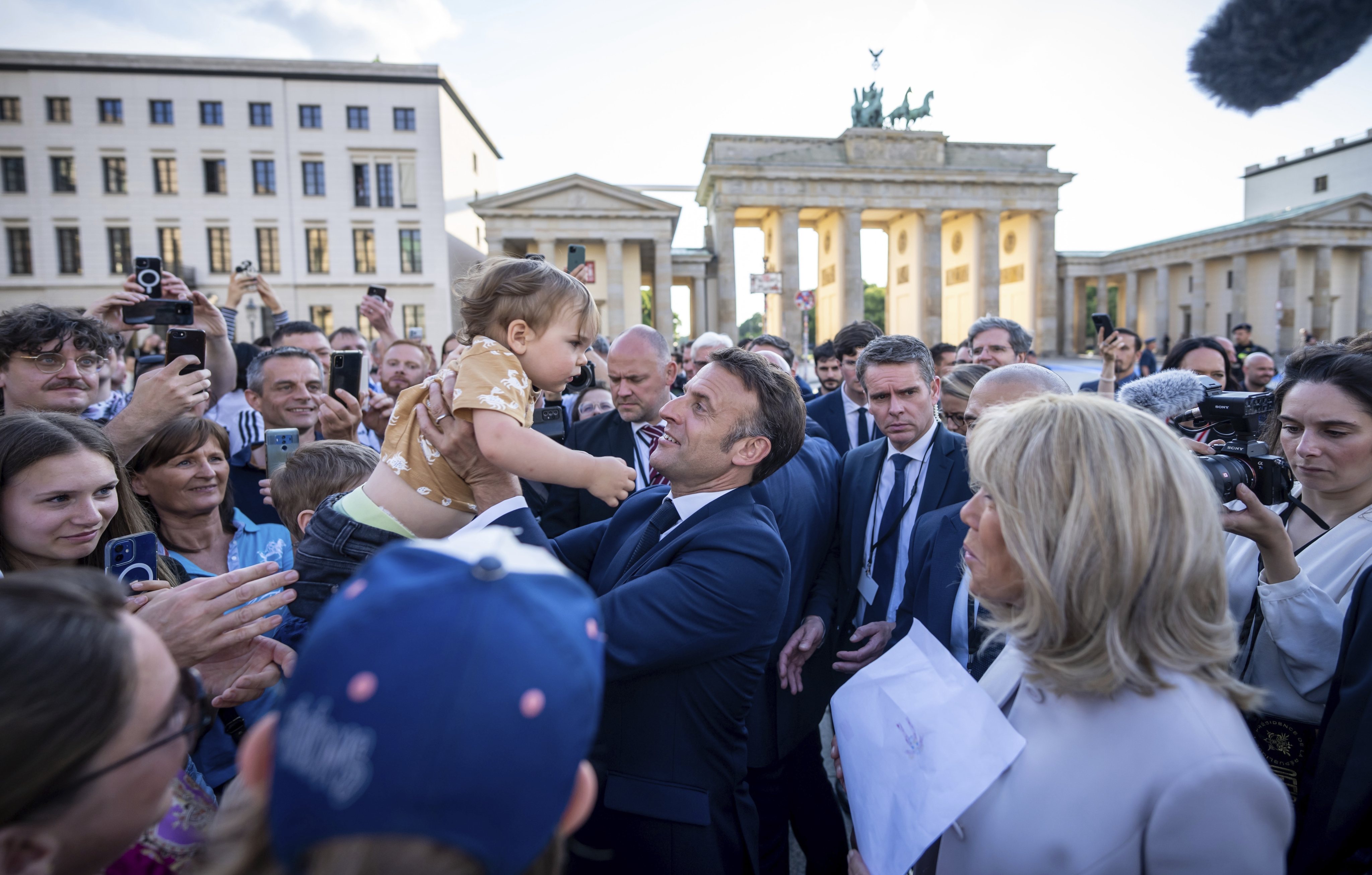 France’s President Emmanuel Macron holds a baby in Berlin, Germany on Sunday. Photo: dpa via AP