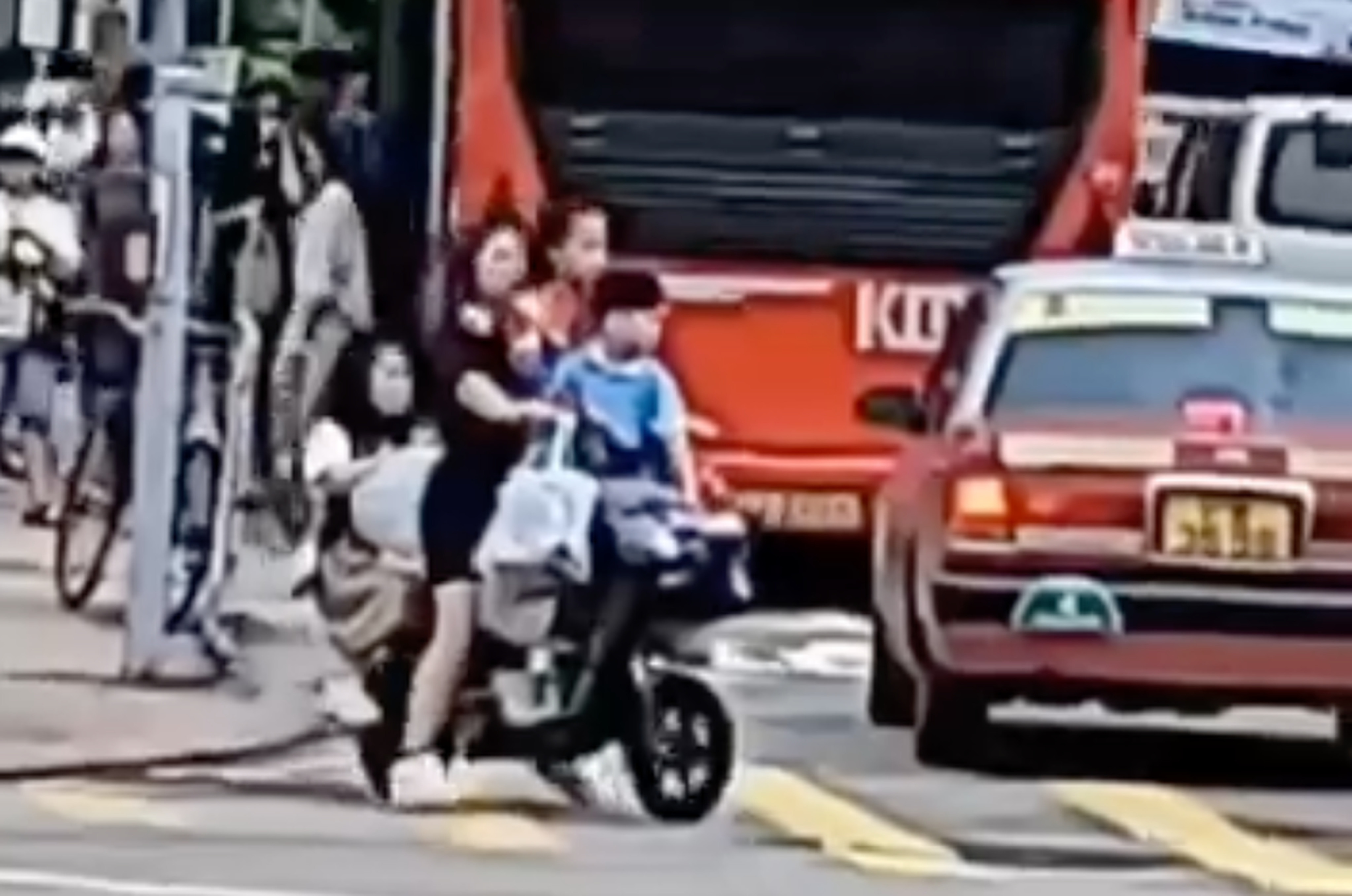 Footage online shows a woman riding a suspected e-bike while carrying three children, all without helmets. Photo: Facebook/香港交通突發報料區