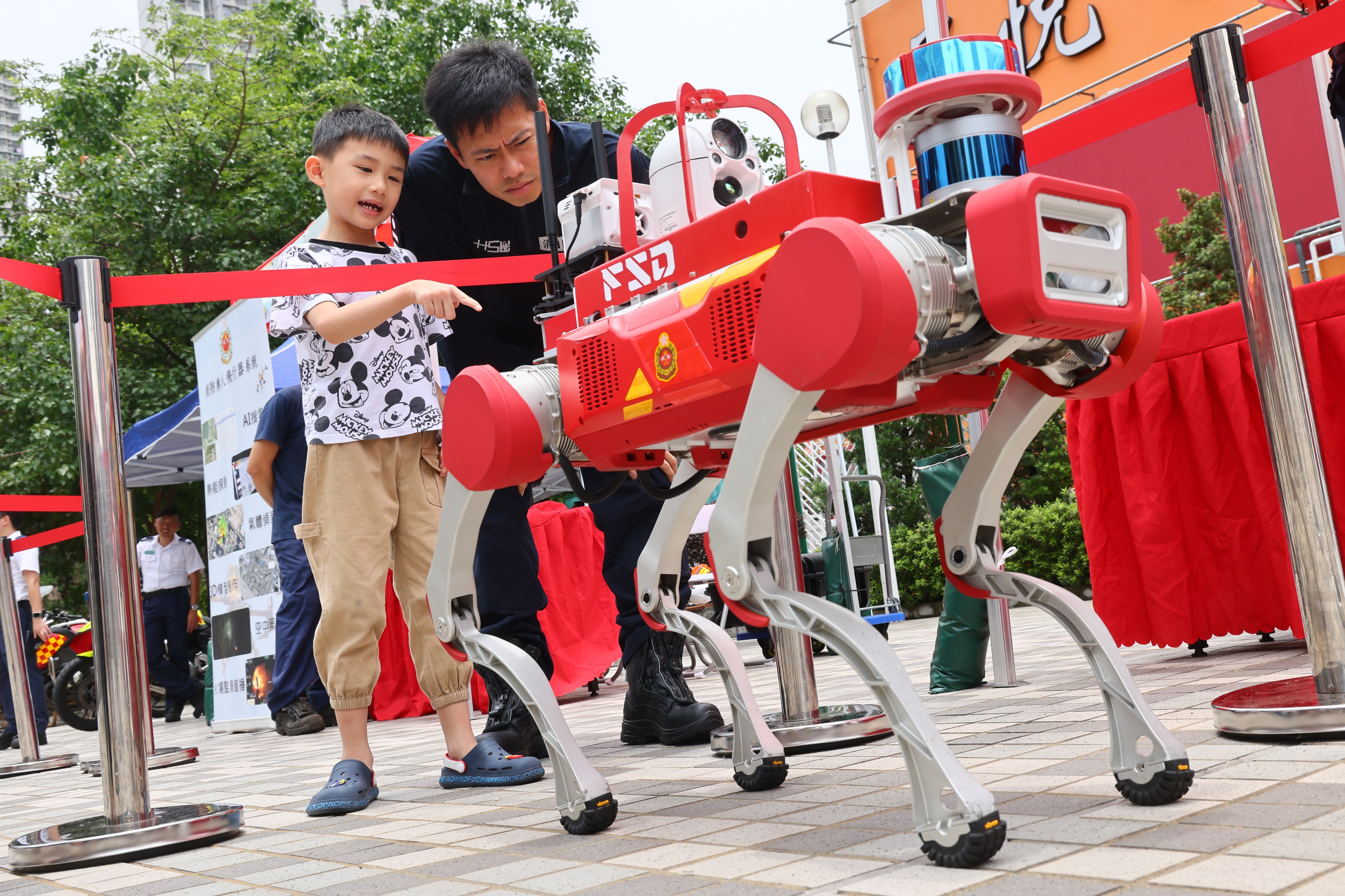 Visitors examine a robotic dog on display during a Fire Services Department publicity campaign at Wong Tai Sin Plaza on May 25. Photo: Dickson Lee