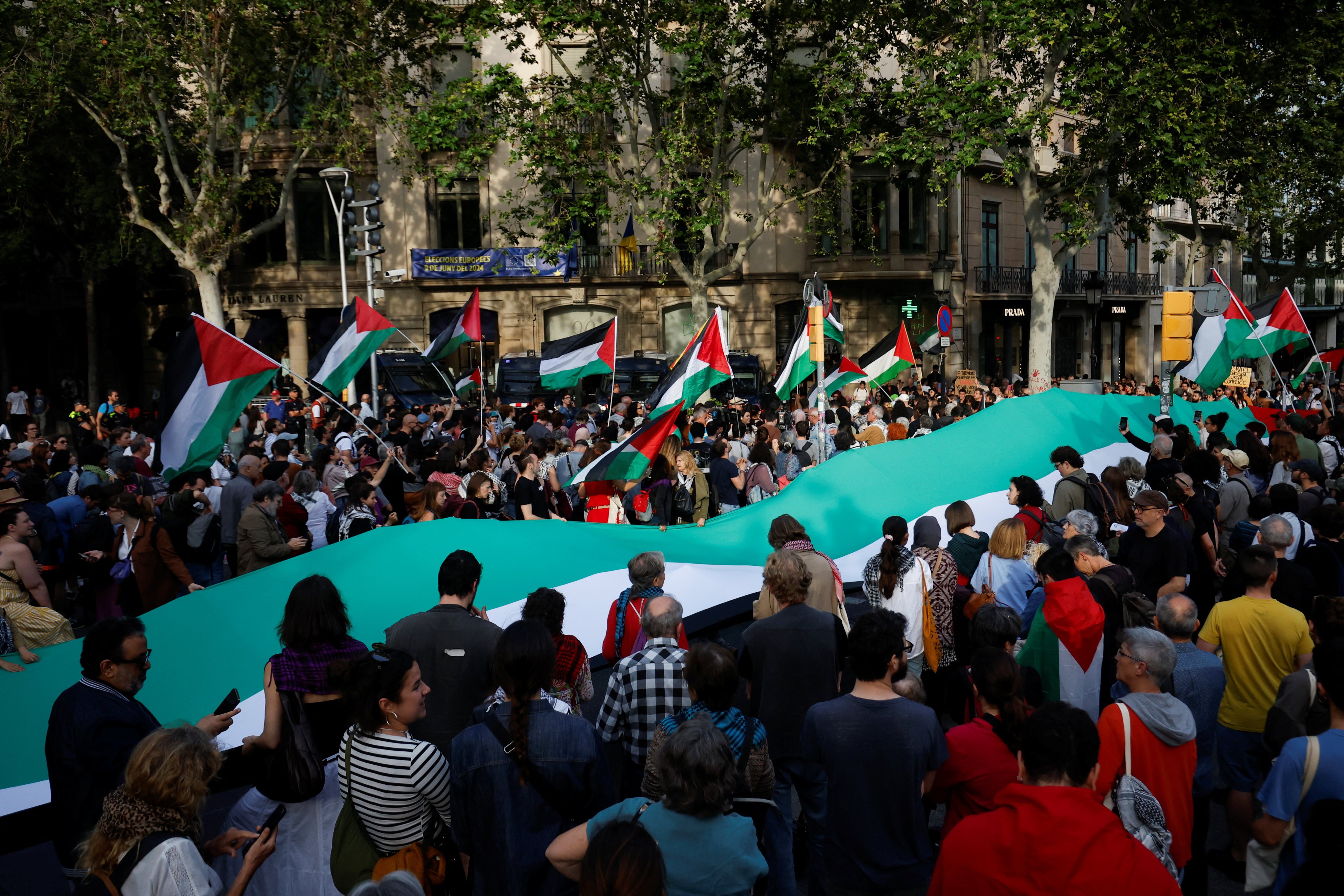 People gather near a giant flag during a pro-Palestinian protest outside an EU office at Passeig de Gracia in Barcelona, Spain on Monday. Photo: Reuters