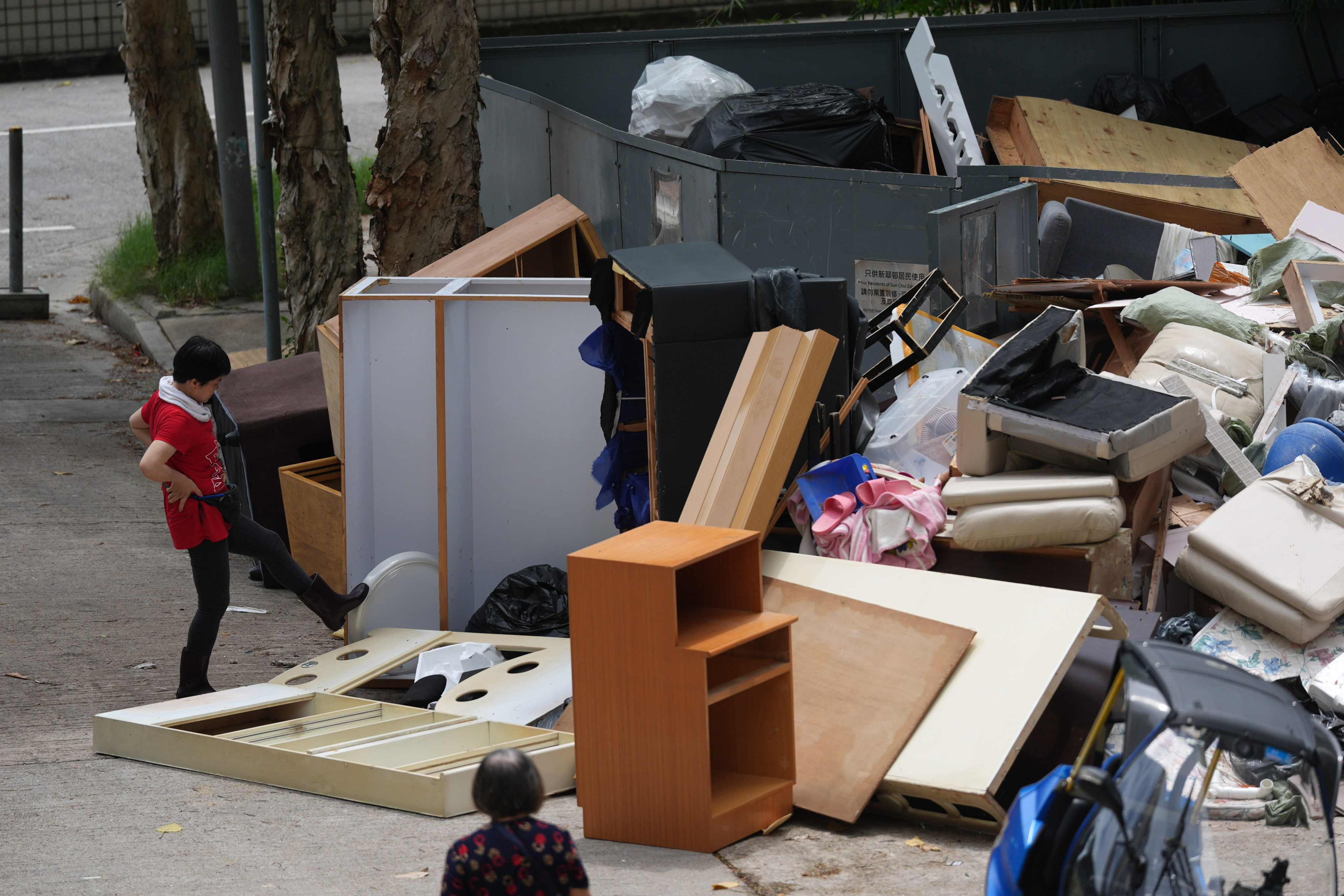 Cleaners dispose household waste at Sun Tsui Estate in Tai Wan as the controversial waste-charging scheme is expected to be shelved with no definite launch date in sight after a two-month trial. Photo: Eugene Lee