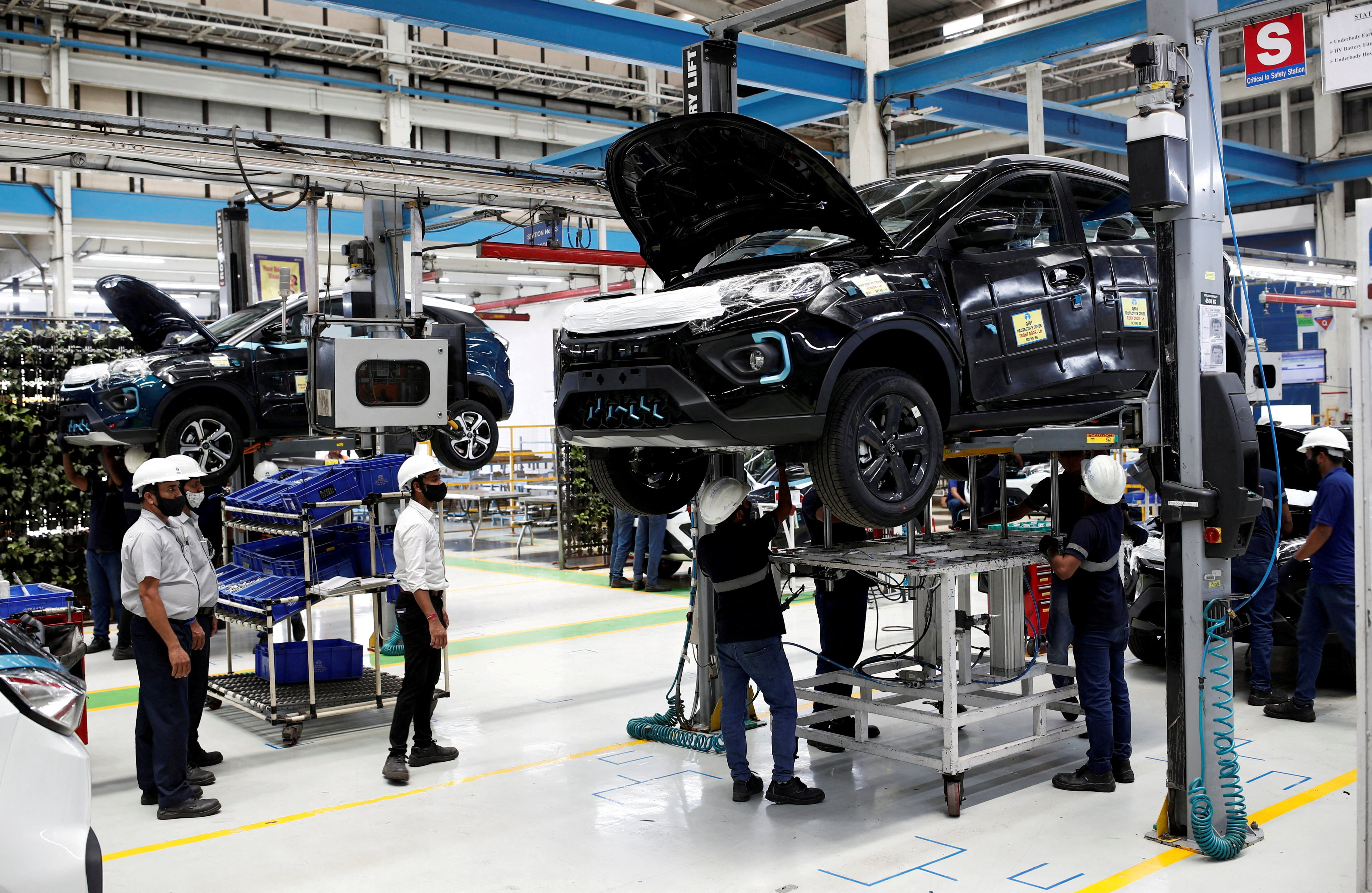 Workers inspect Tata Nexon electric sport utility vehicles at a Tata Motors plant in Pune, India, on April 7, 2022. The electric vehicle market in India is growing rapidly and cost-conscious consumers will be looking to new entrants to rev things up. Photo: Reuters