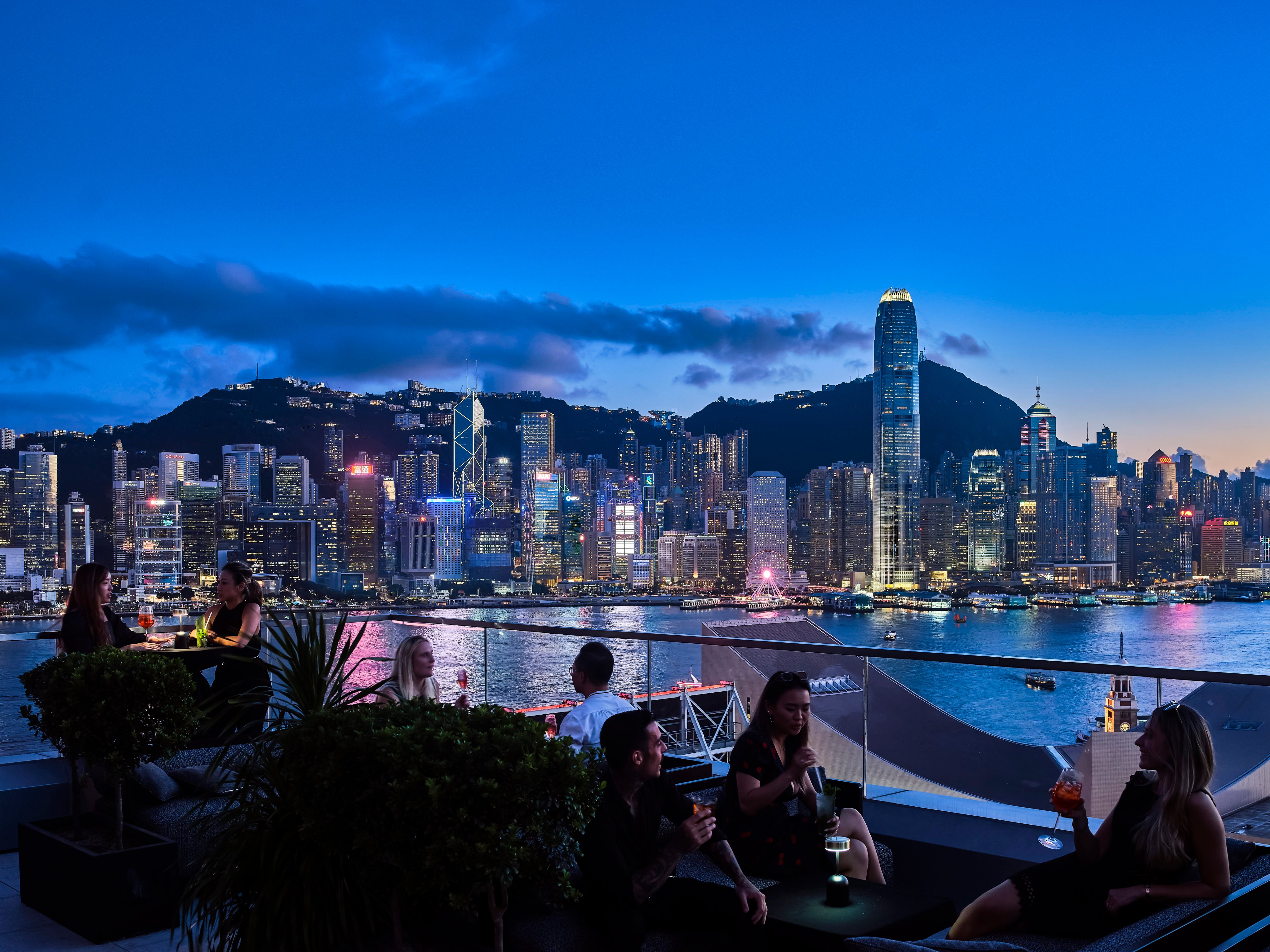 Diners enjoy drinks with views of the city skyline from the terrace at Aqua, one of many Hong Kong restaurants enticing diners with seasonal promotions this summer. Photo: Handout