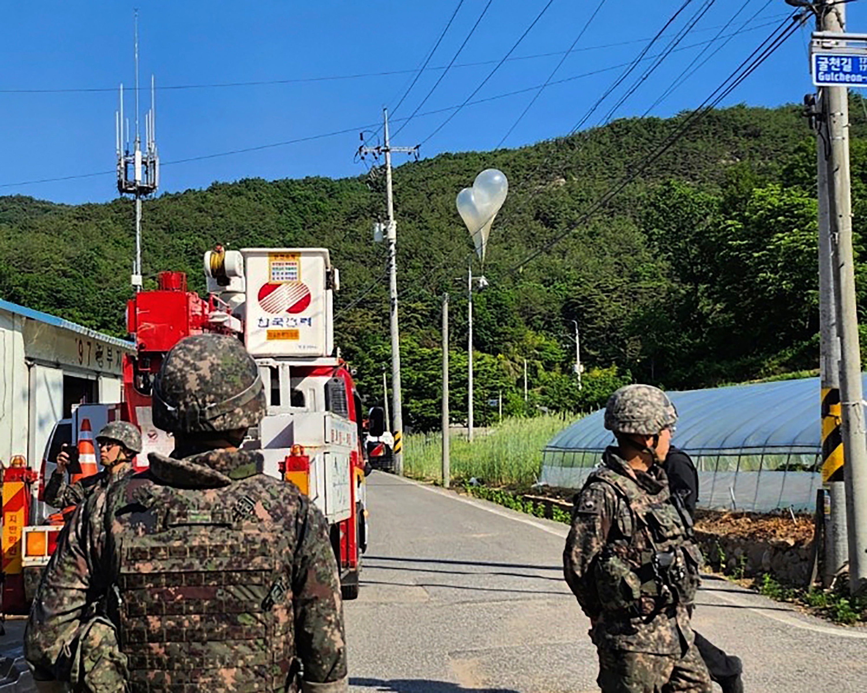 Balloons with garbage sent by North Korea, hang on electric wires as South Korean army soldiers stand guard in Muju. Photo: AP