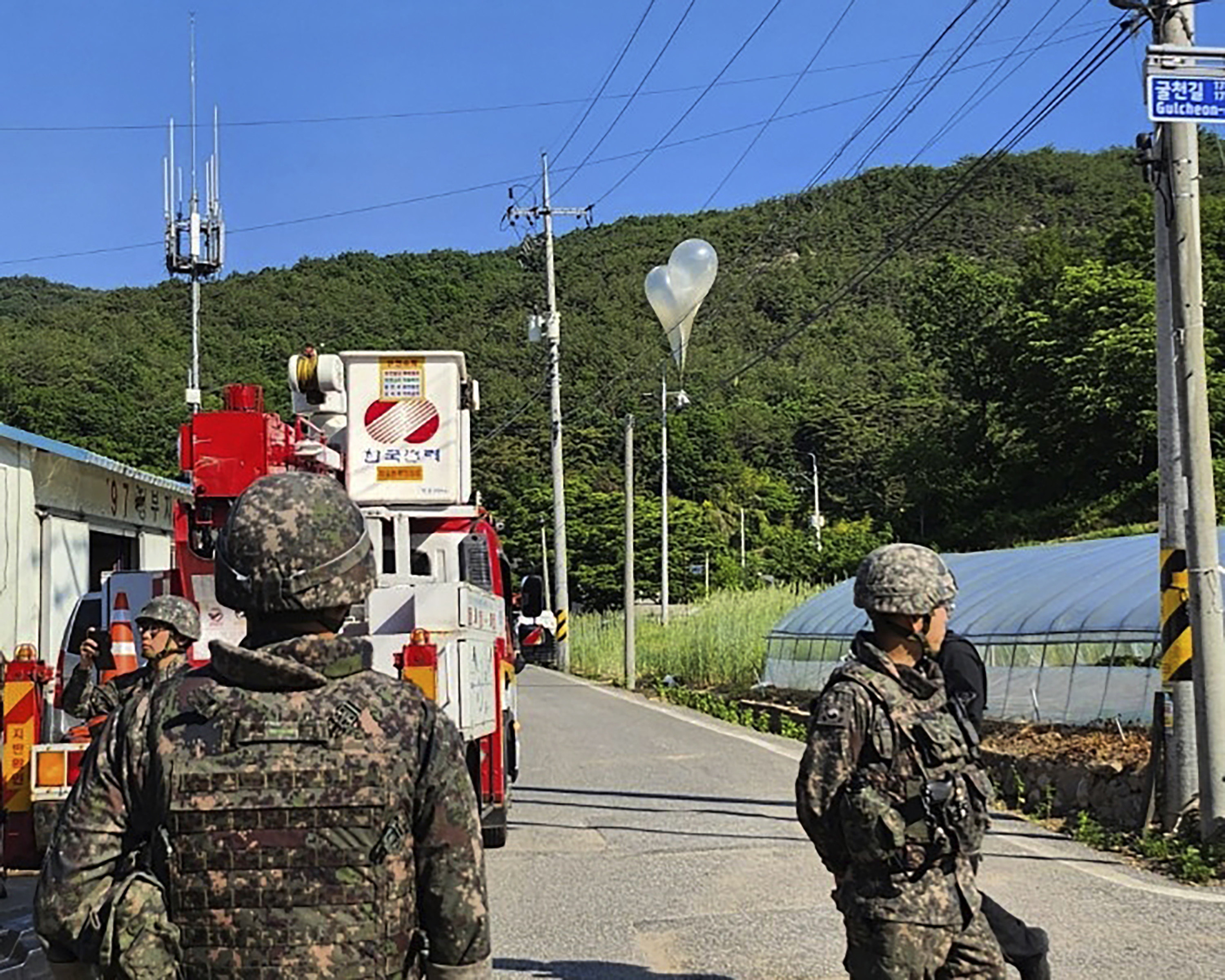 Balloons with garbage sent by North Korea, hang on electric wires as South Korean army soldiers stand guard in Muju. Photo: AP