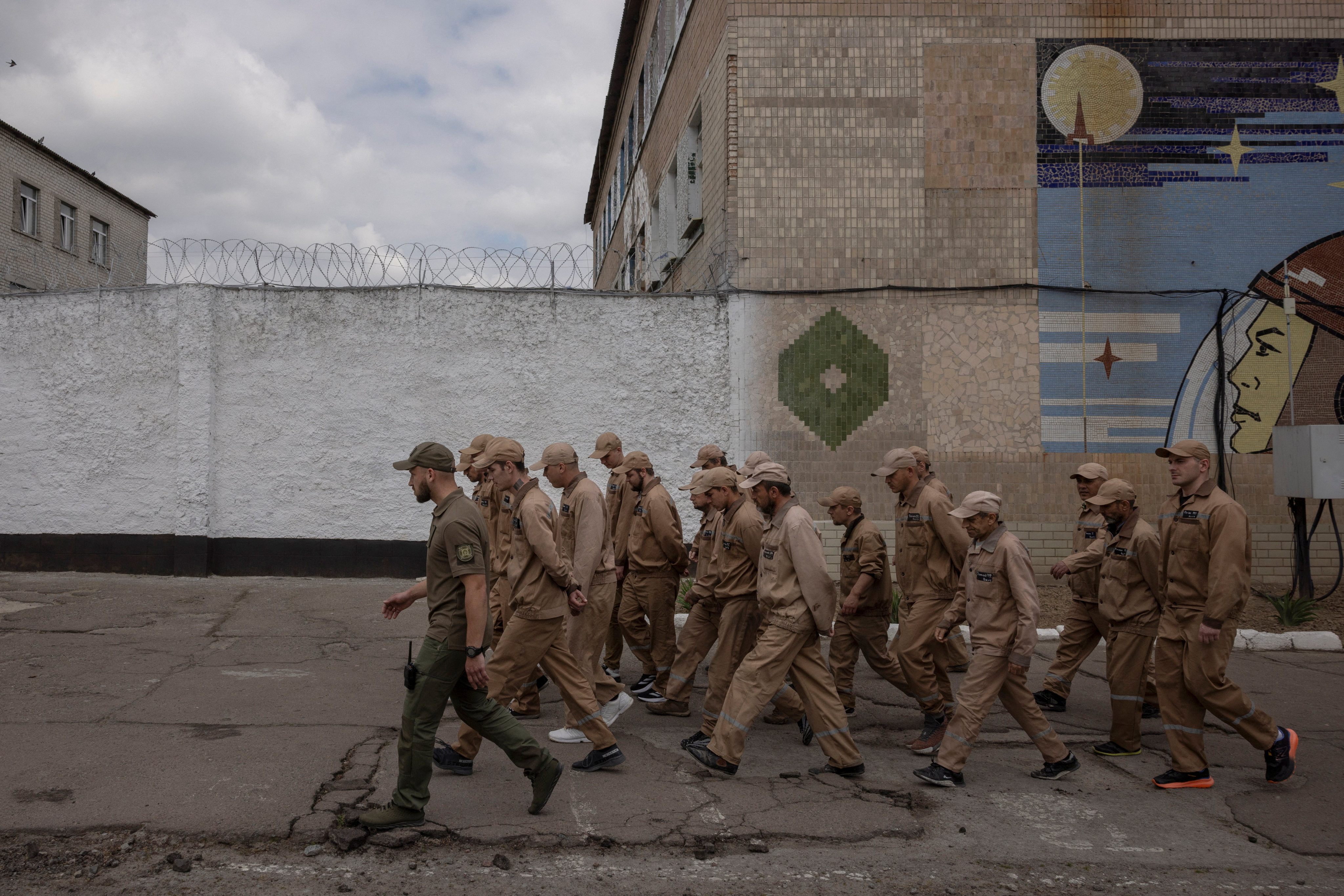 Inmates walk in a prison yard following a government offer to recruit some convicts for the military, in a prison colony in the Kyiv region. Photo: Reuters